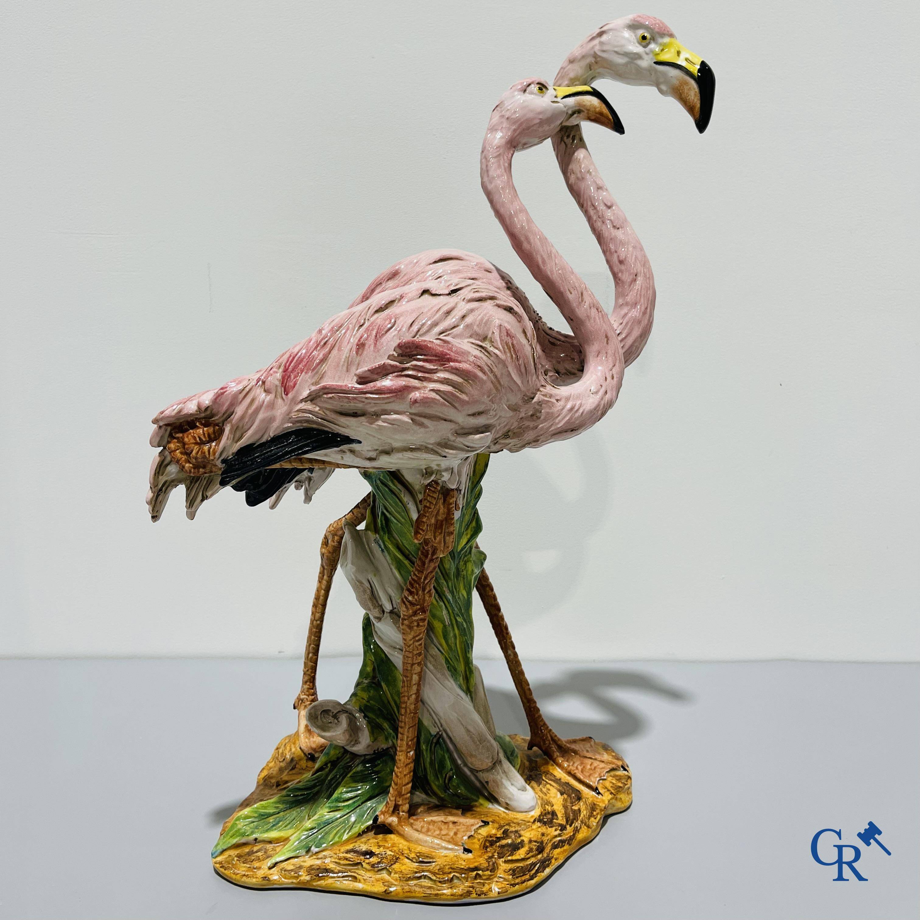 Een paar flamingo's in majolica in de stijl van Massier.