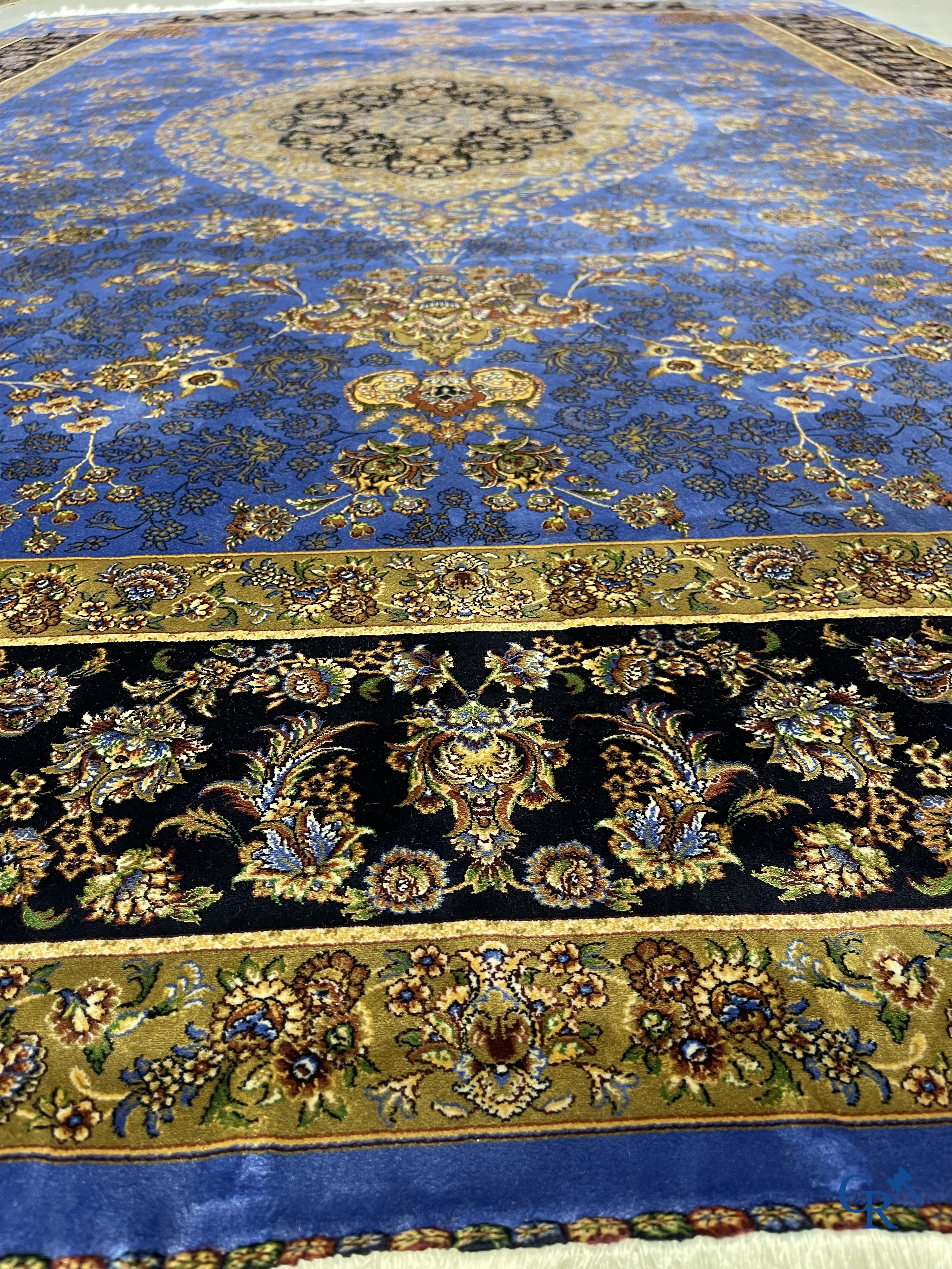 Tapis. Exceptionnel tapis en soie avec un décor floral sur fond bleu.