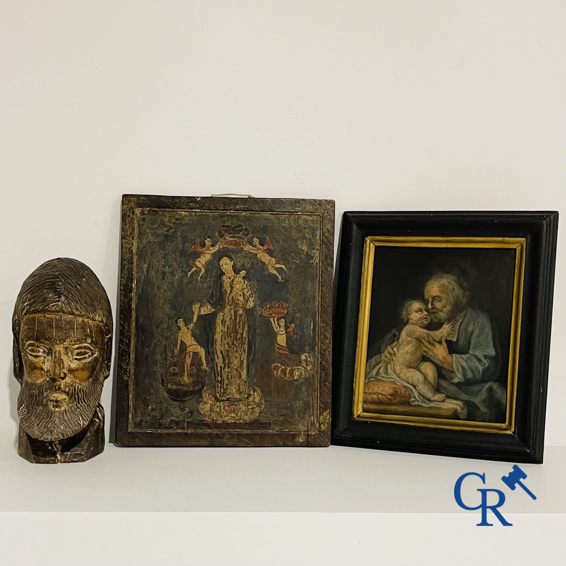 2 religious paintings and a wooden sculpted head of a saint.<br />
19th century.