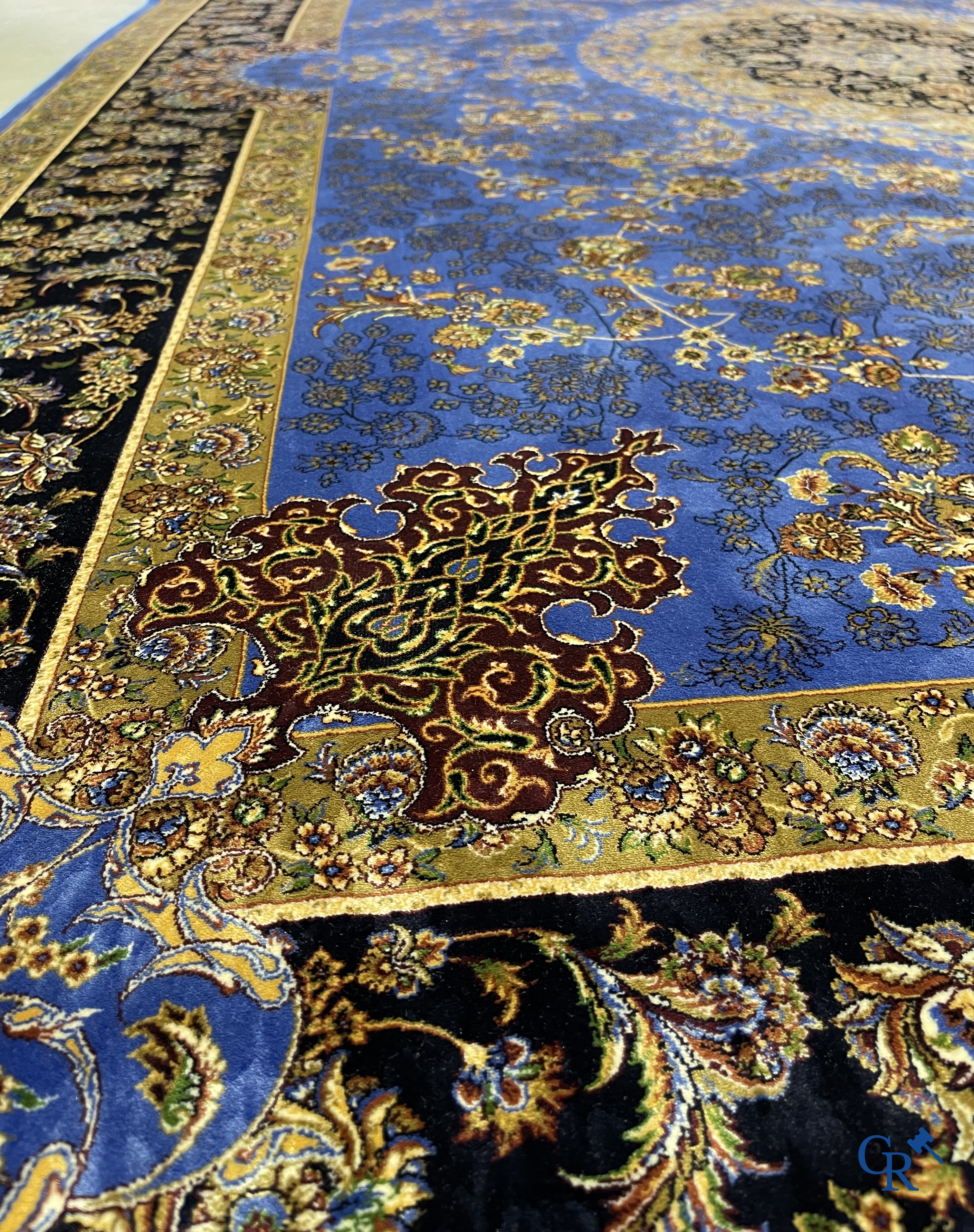 Tapis. Exceptionnel tapis en soie avec un décor floral sur fond bleu.