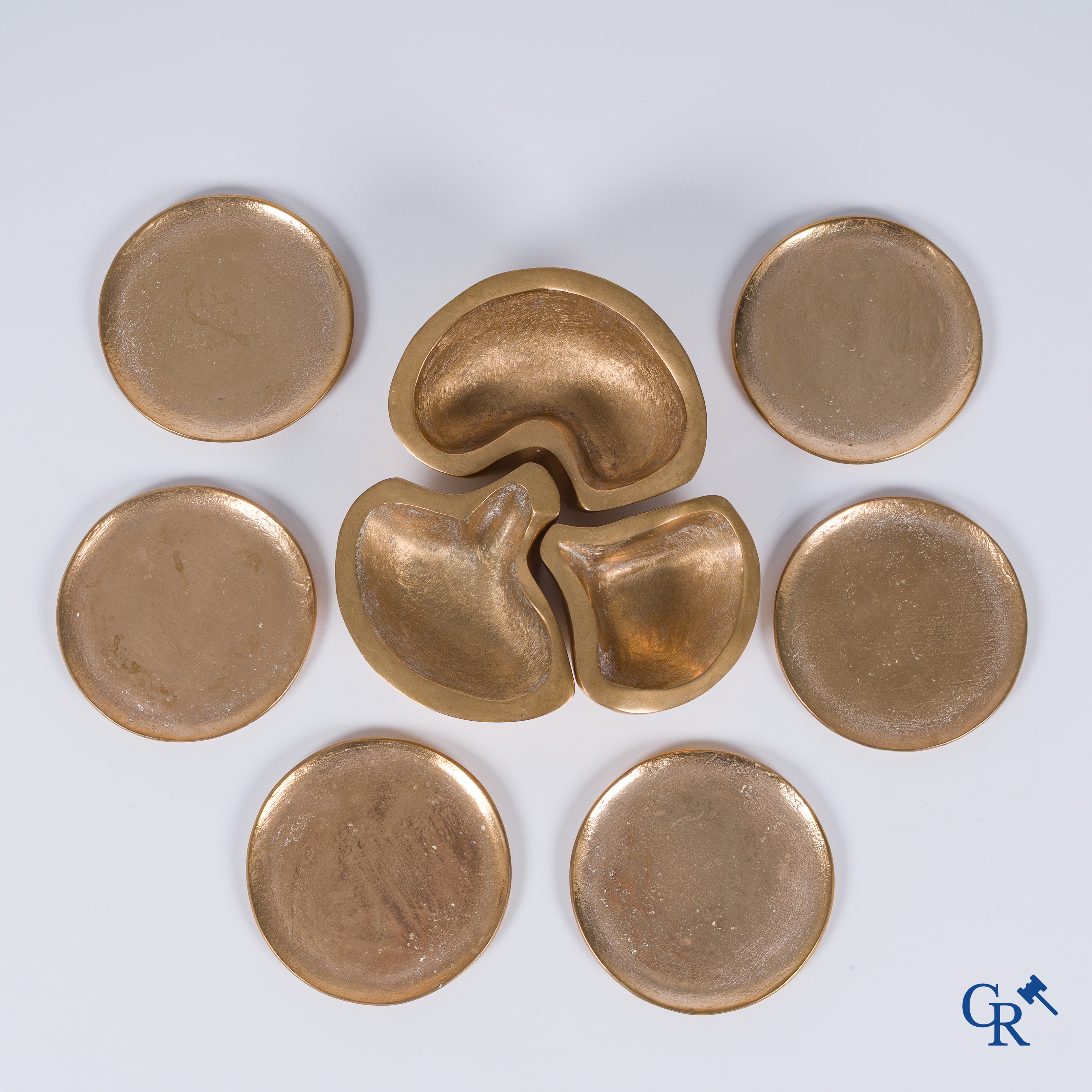 Margrit Van Nuffel (1943) Een 3-delige tafelset en een set van 6 onderleggers in gepolijst massieve brons. Circa 1970.