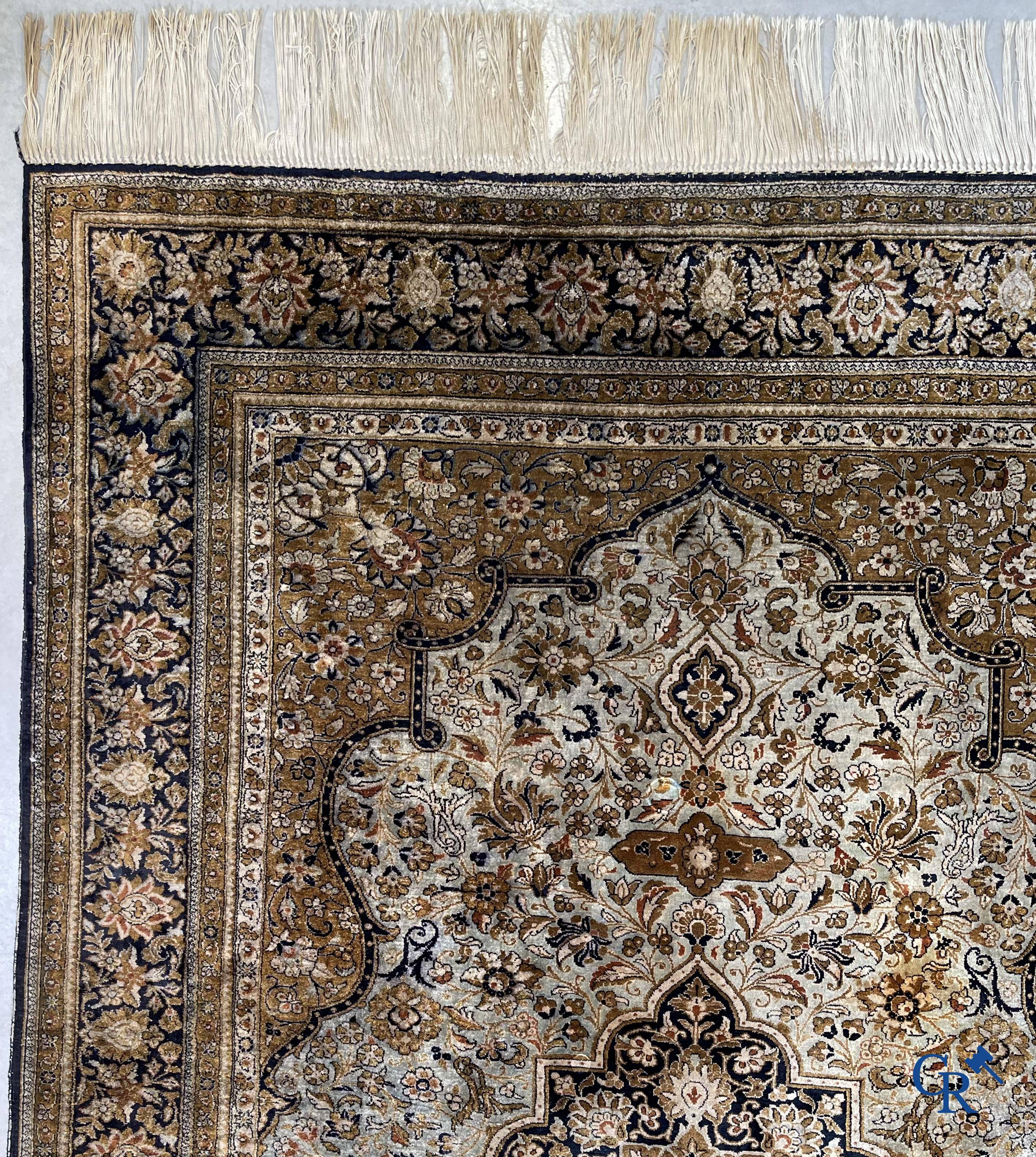 Tapis d'Orient. Un tapis en soie finement noué à la main avec un décor floral.