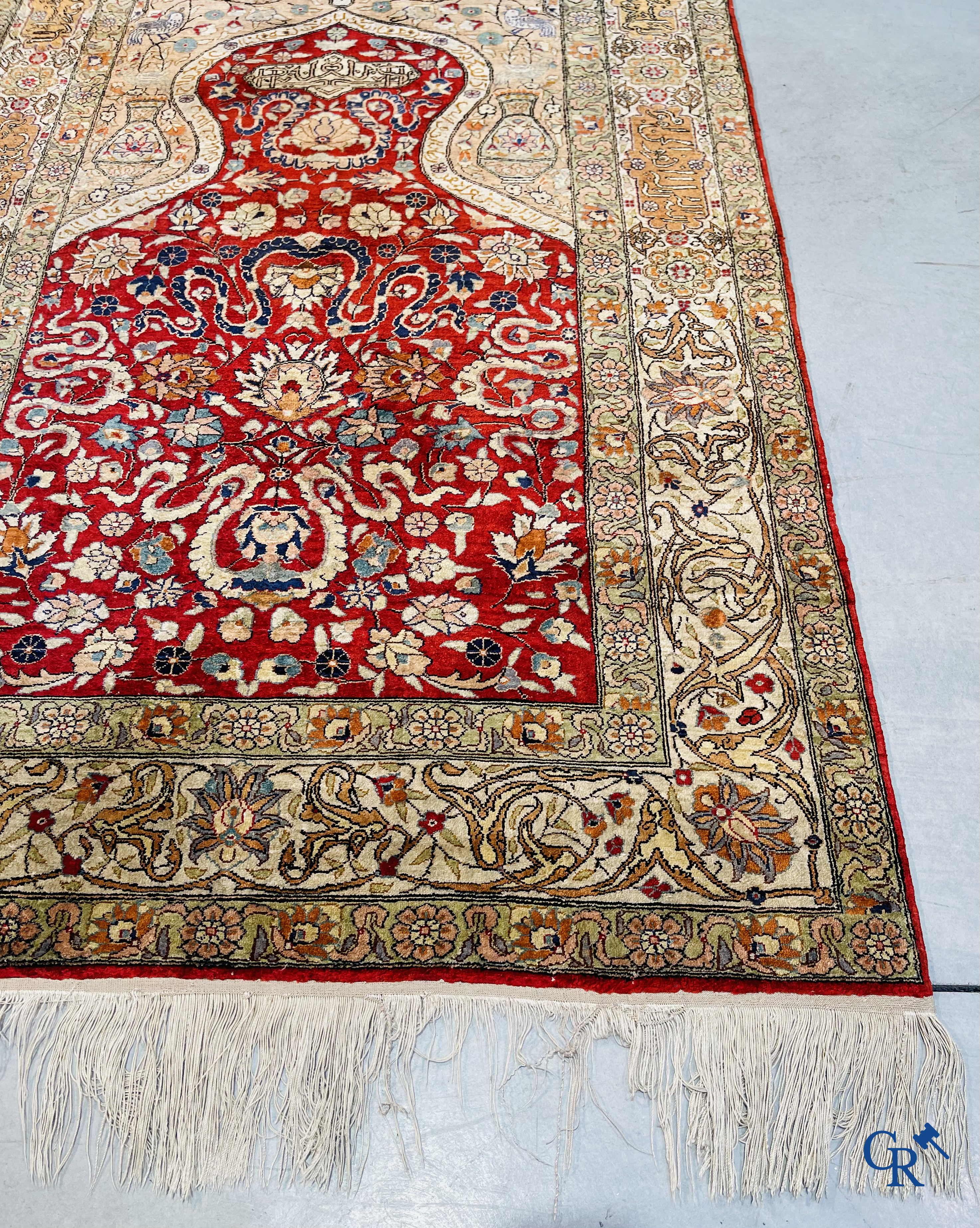 Oriental carpets: Hereke, a finely knotted silk carpet with inscriptions and birds in a floral decor.