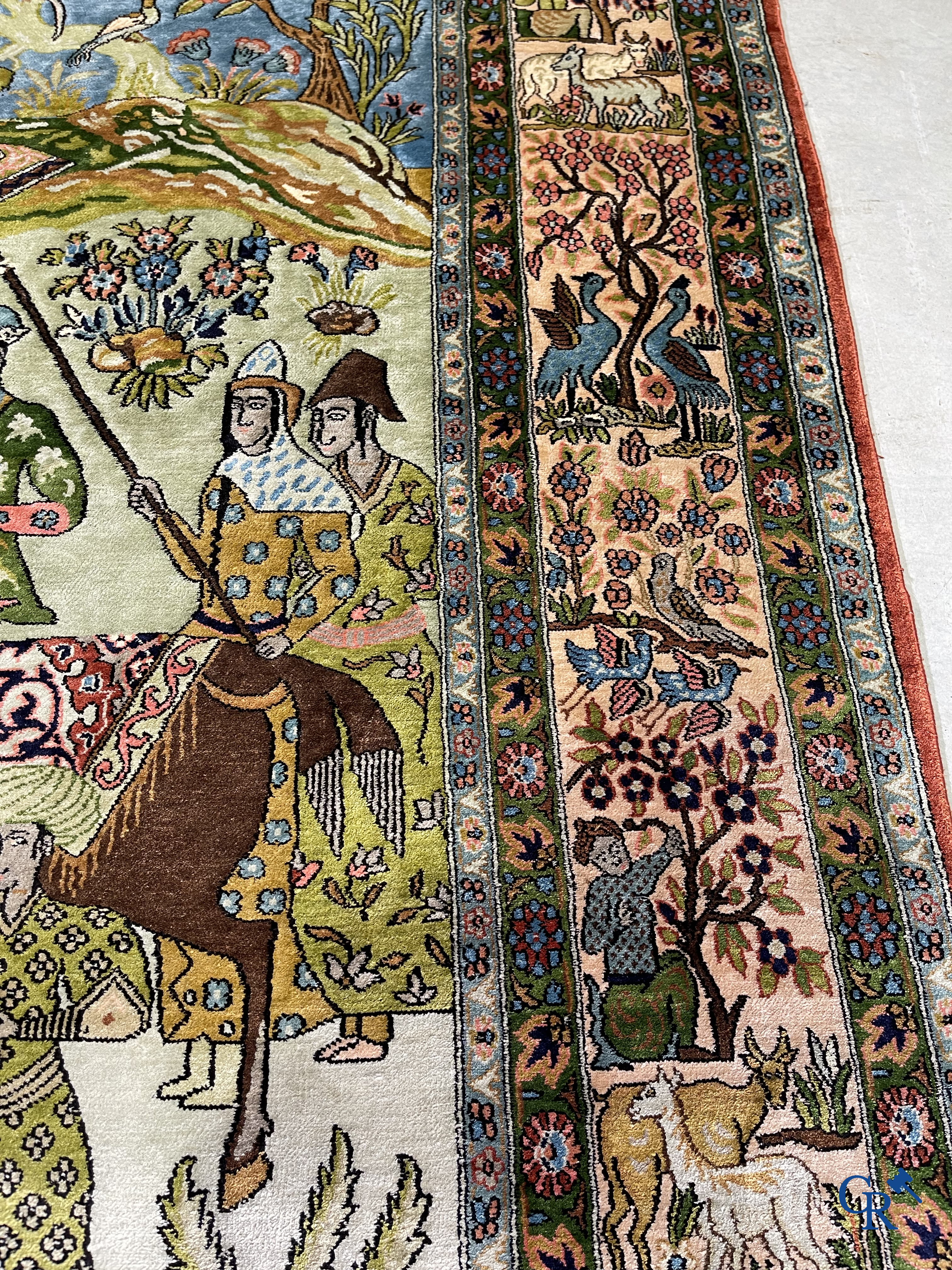 Tapis d'Orient. Iran. Un tapis persan en soie finement noué à la main avec des personnages et un cheval dans un paysage.