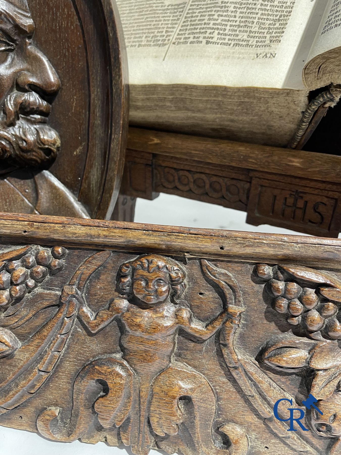 A lot with various antique wood sculptures and an antique book on a reading table.