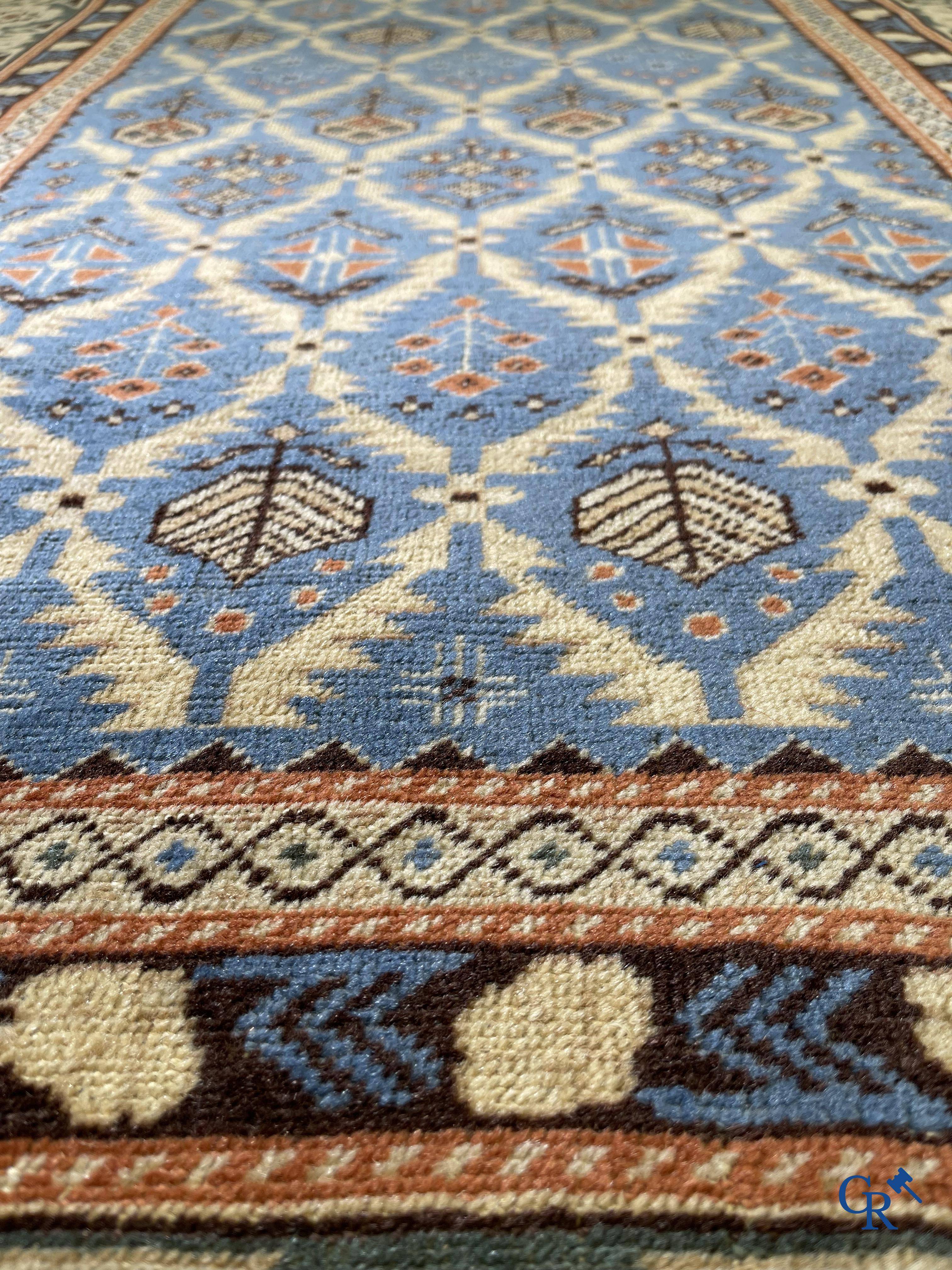 Antique Oriental carpets, an antique Dagestan carpet with motifs on a blue background.