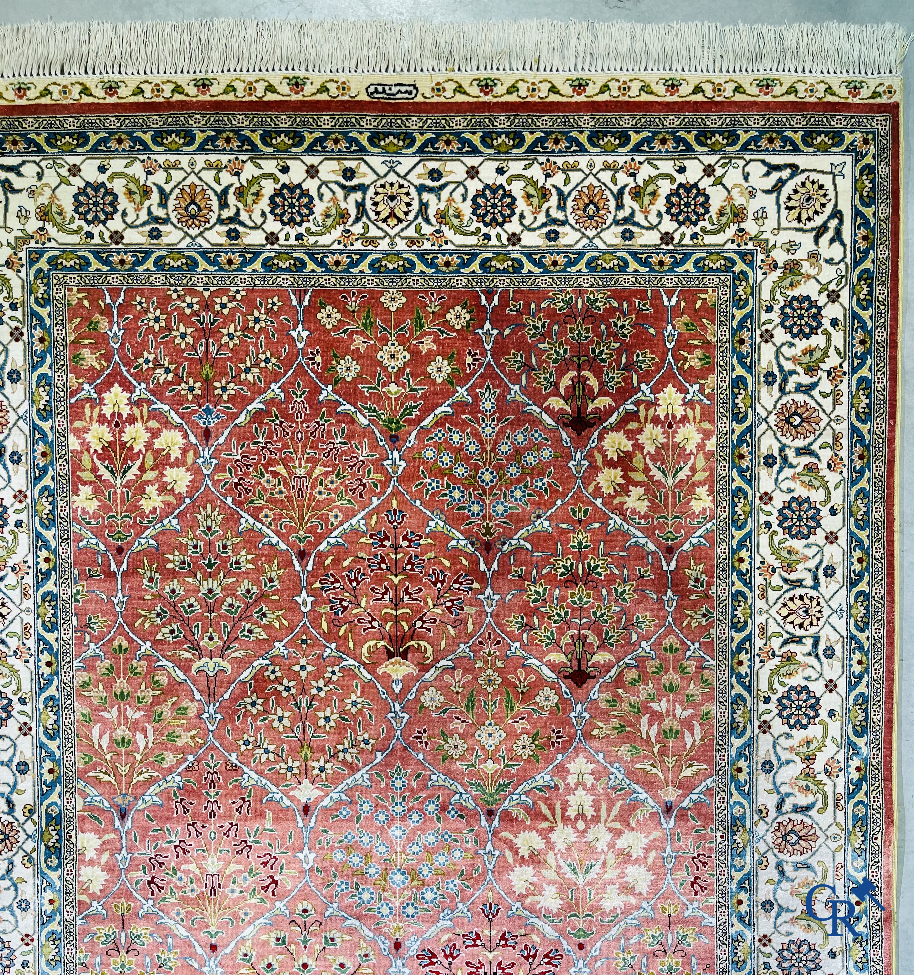 Tapis d'Orient: Un tapis finement noué à la main en laine et soie avec un décor floral.<br />
Signé.