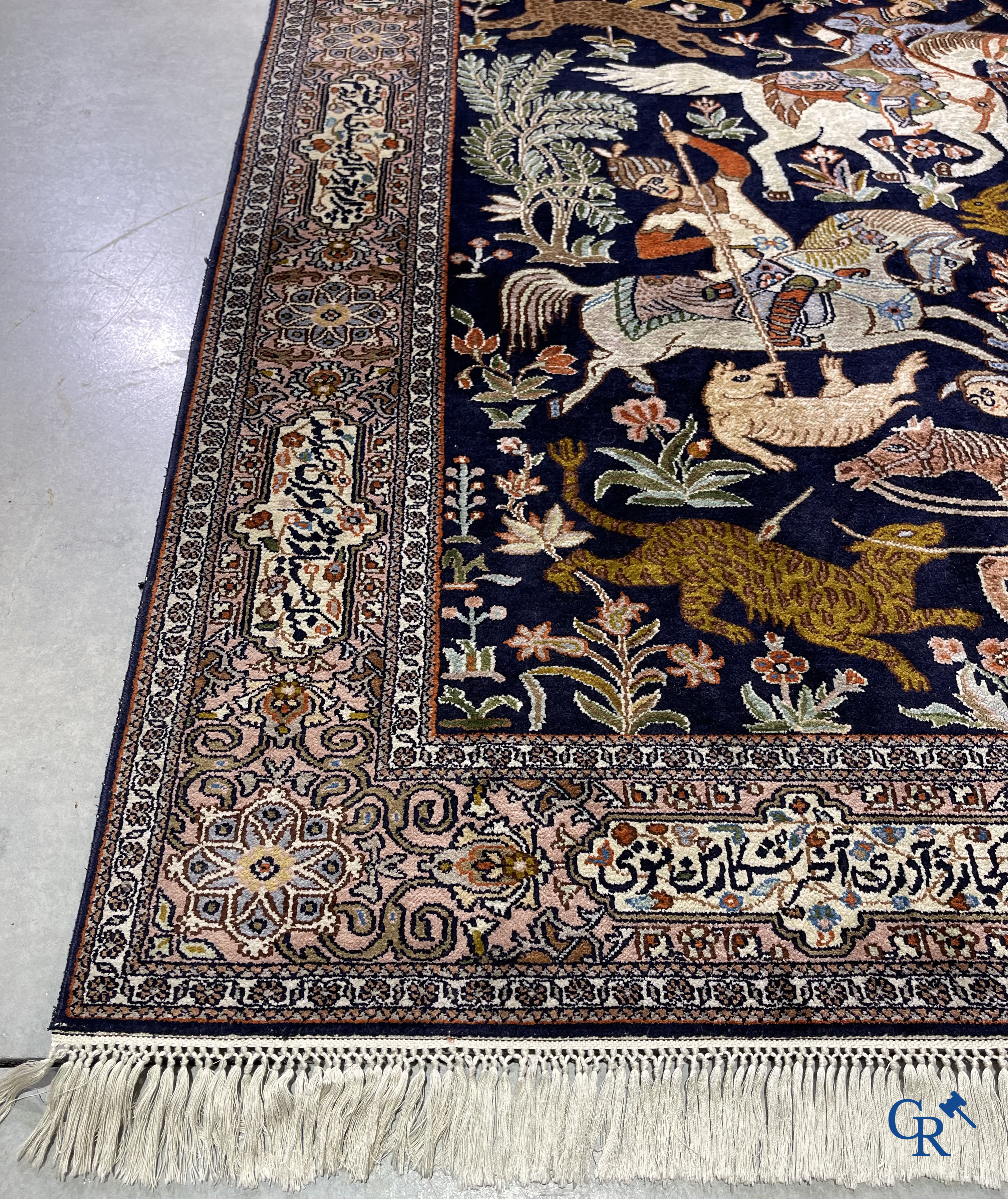 Oriental rugs. Iran. A finely hand-knotted Persian rug in wool and silk with hunters on horseback and inscriptions.