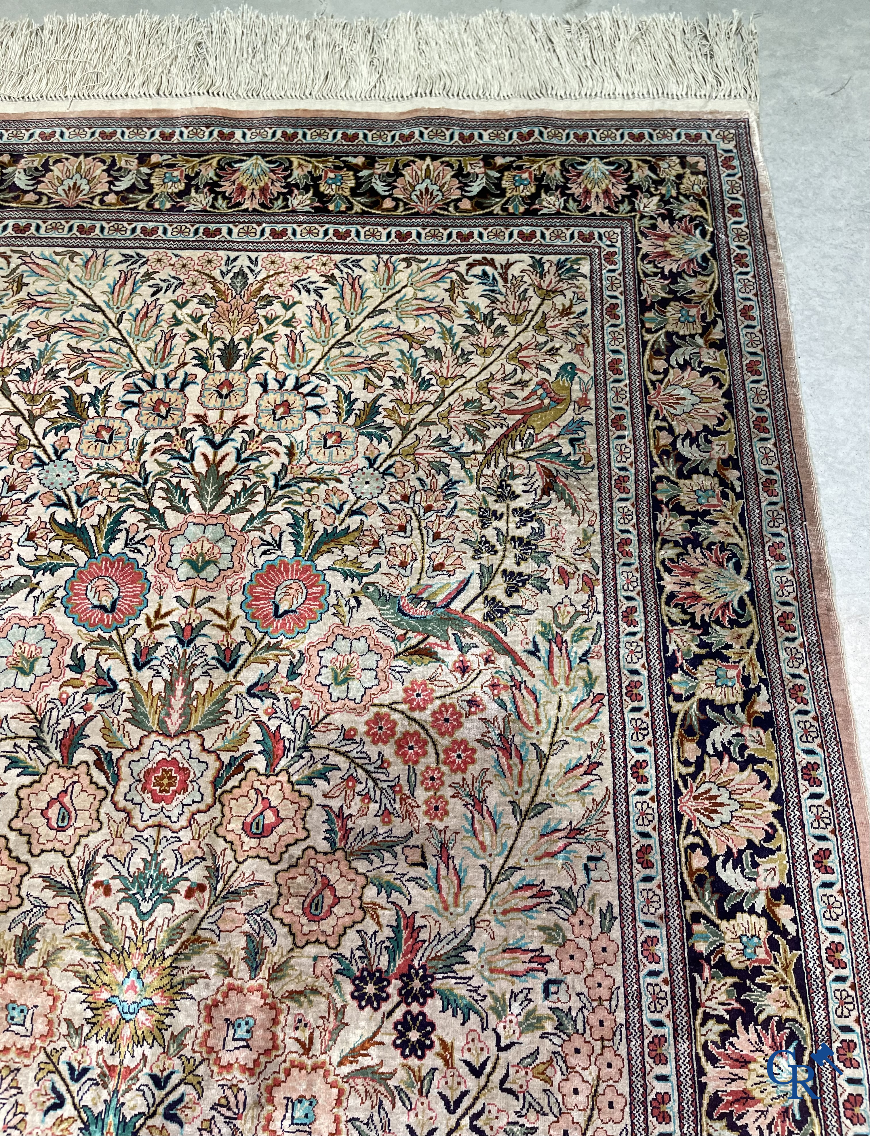 Tapis d'Orient: Un tapis persan en soie finement noué à la main avec un vase à fleurs et des oiseaux dans un décor floral.