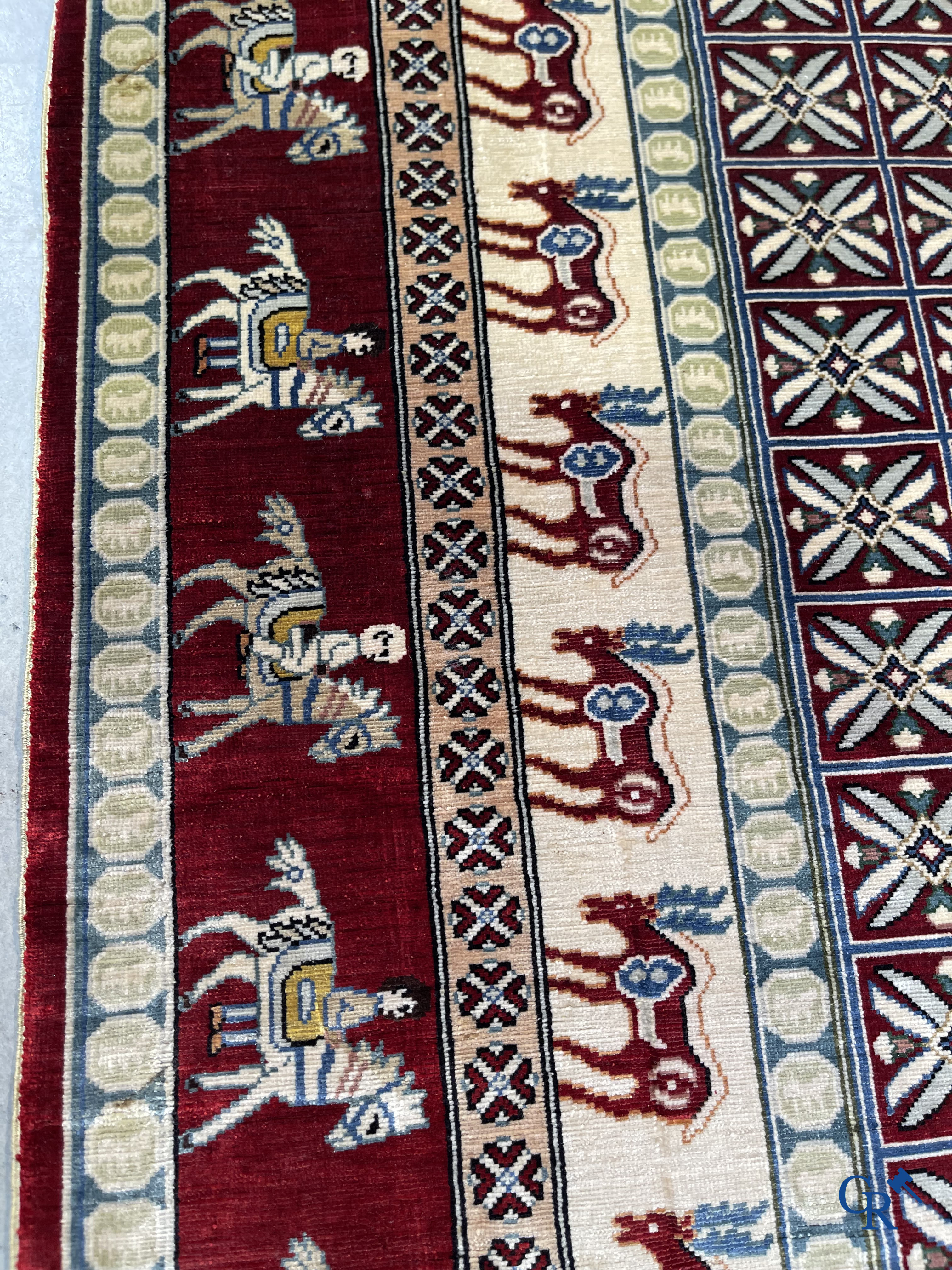 Oriental rugs: A small finely hand-knotted silk rug with deer and horsemen. Signed.