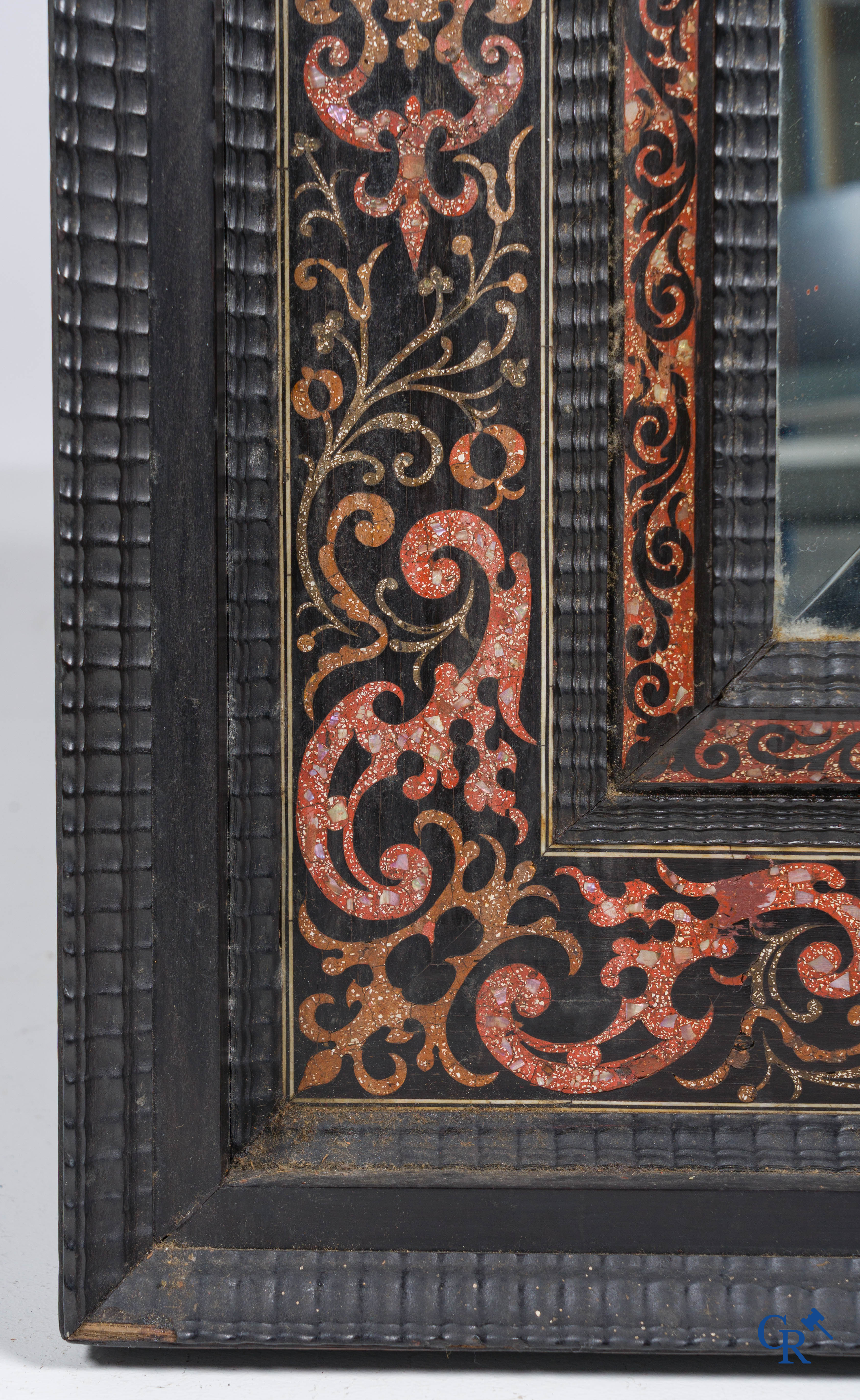 Een spiegel in ebbenhout en inlegwerk. 18e- 19e eeuw.