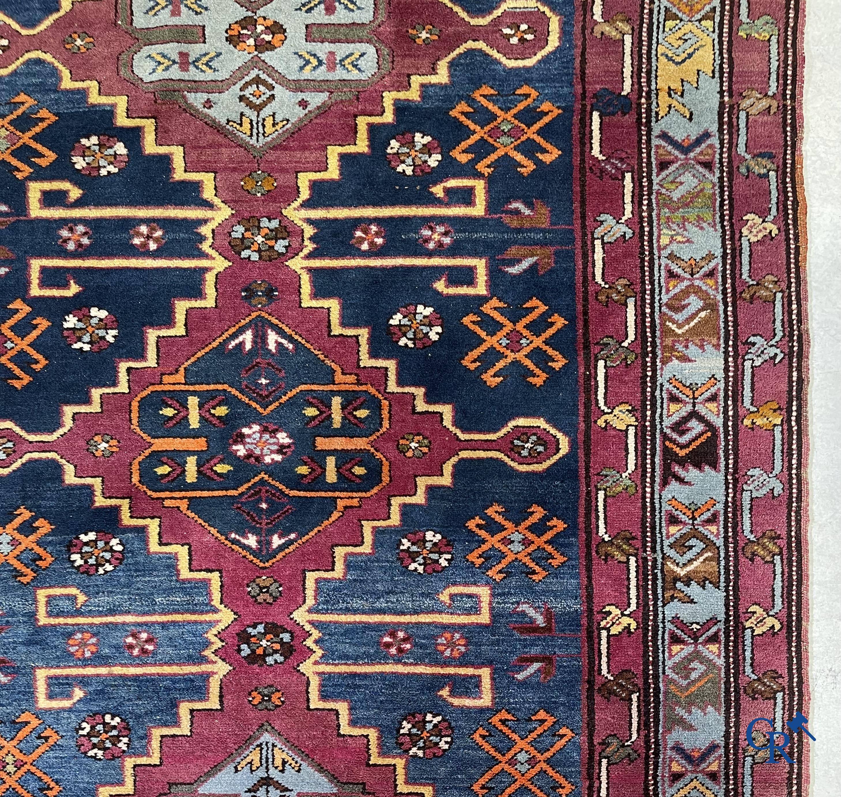 Oriental carpets, an antique hand-knotted Oriental carpet with motifs on a blue background.