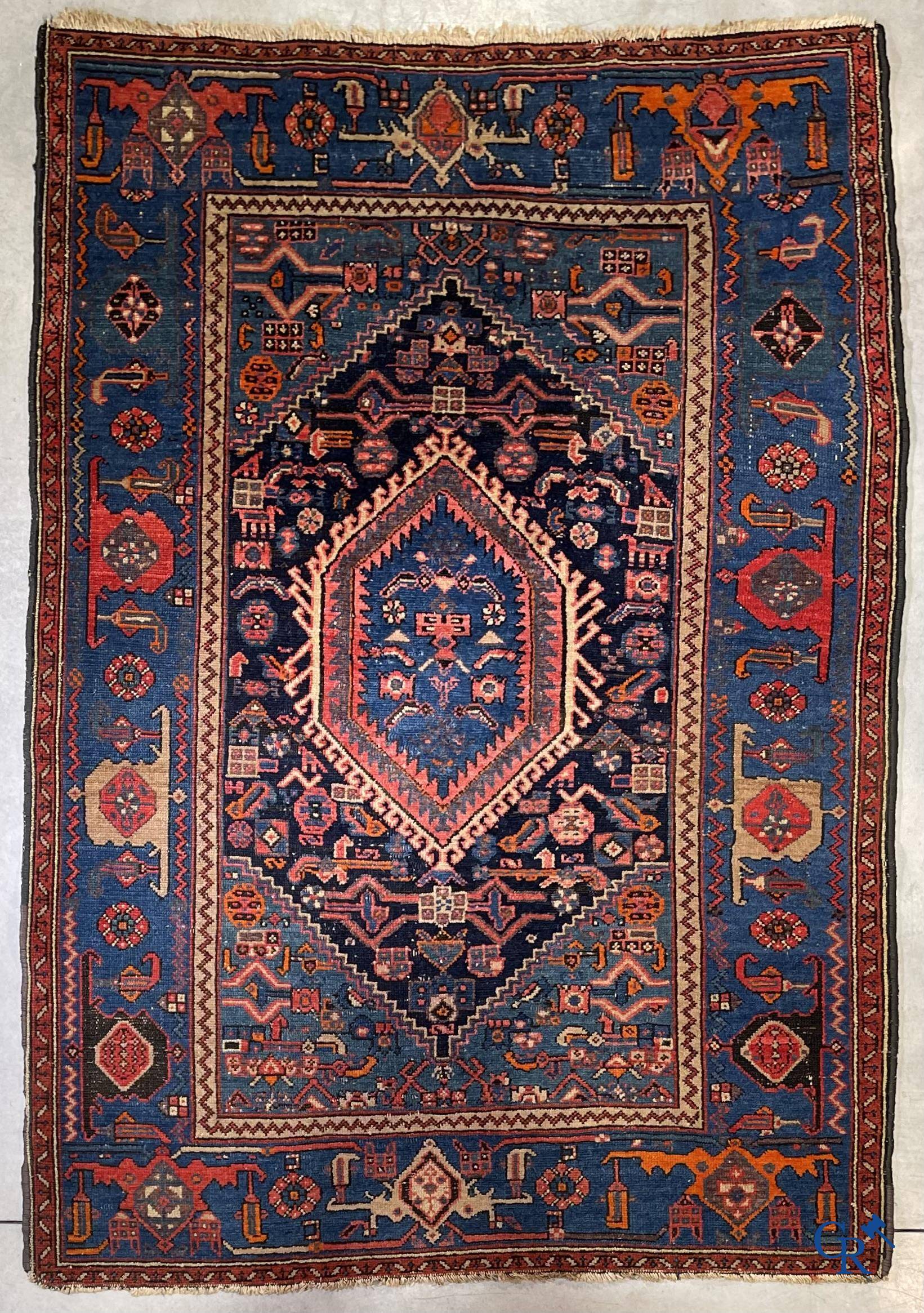 Antique Oriental carpets, an antique hand-knotted carpet with motifs on a blue background.