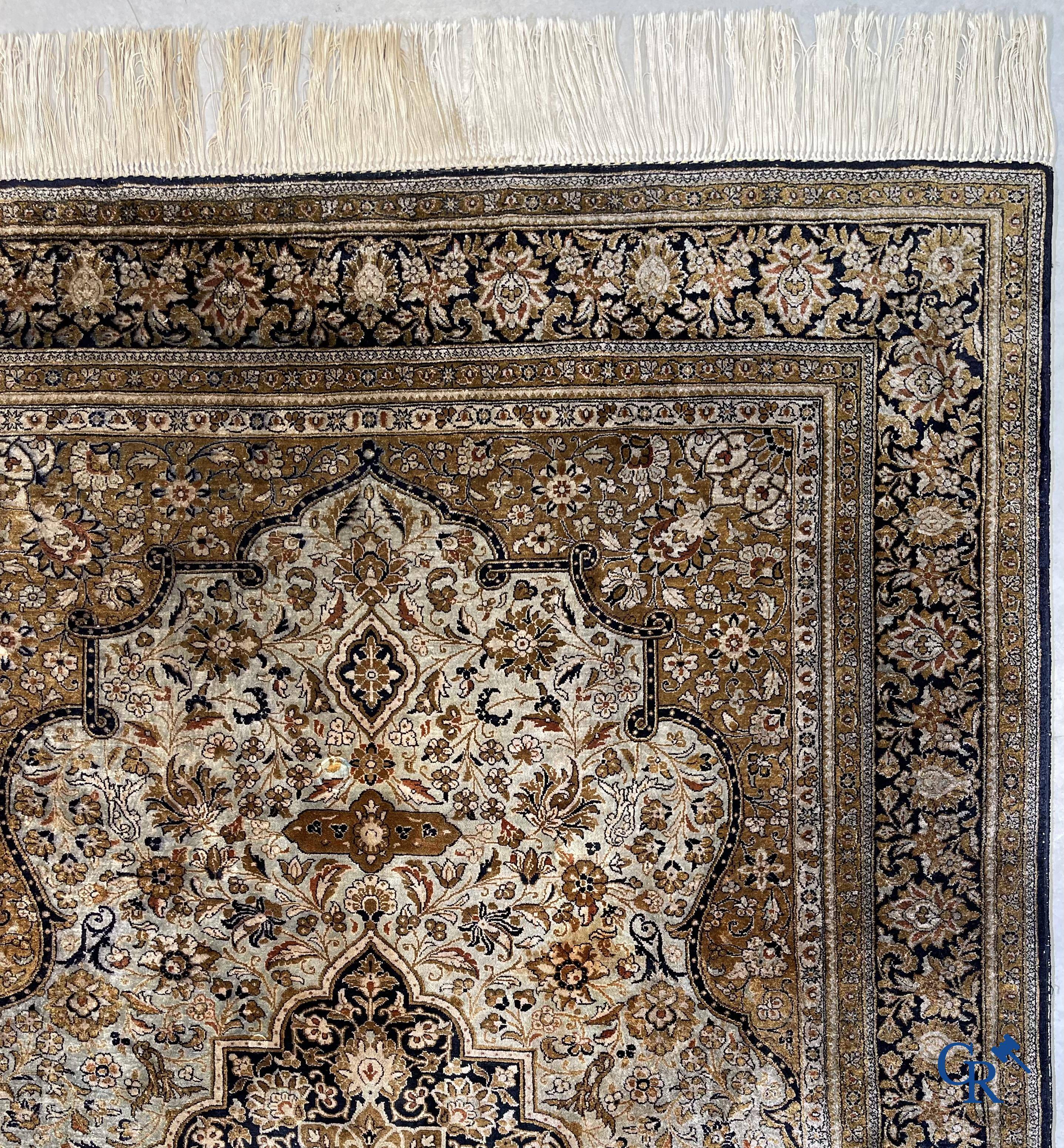 Tapis d'Orient. Un tapis en soie finement noué à la main avec un décor floral.