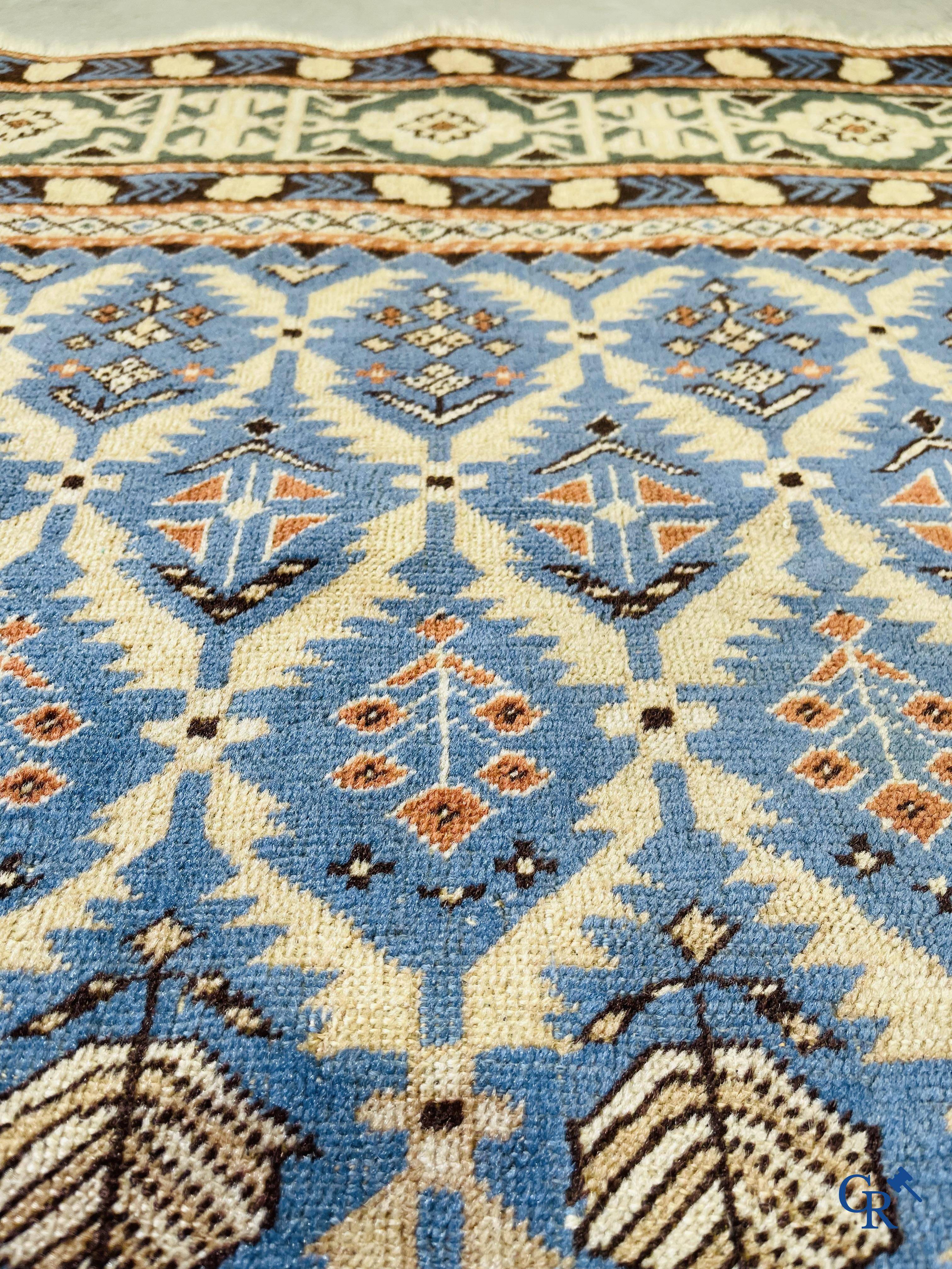 Antique Oriental carpets, an antique Dagestan carpet with motifs on a blue background.