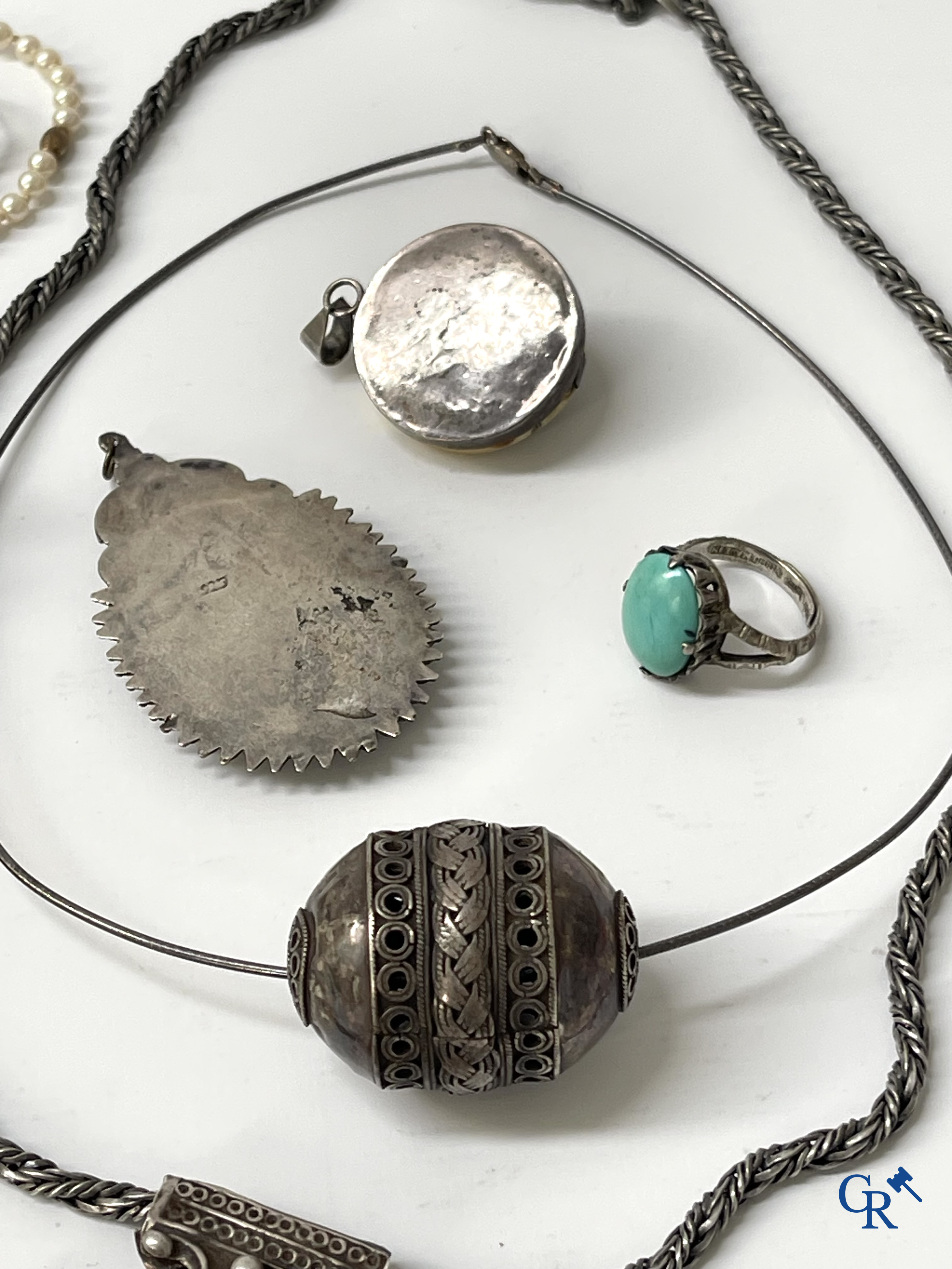 Juwelen. Lot objecten en juwelen in zilver of met zilver montuur. Een lot met uurwerken en juwelen in metaal bijgevoegd.