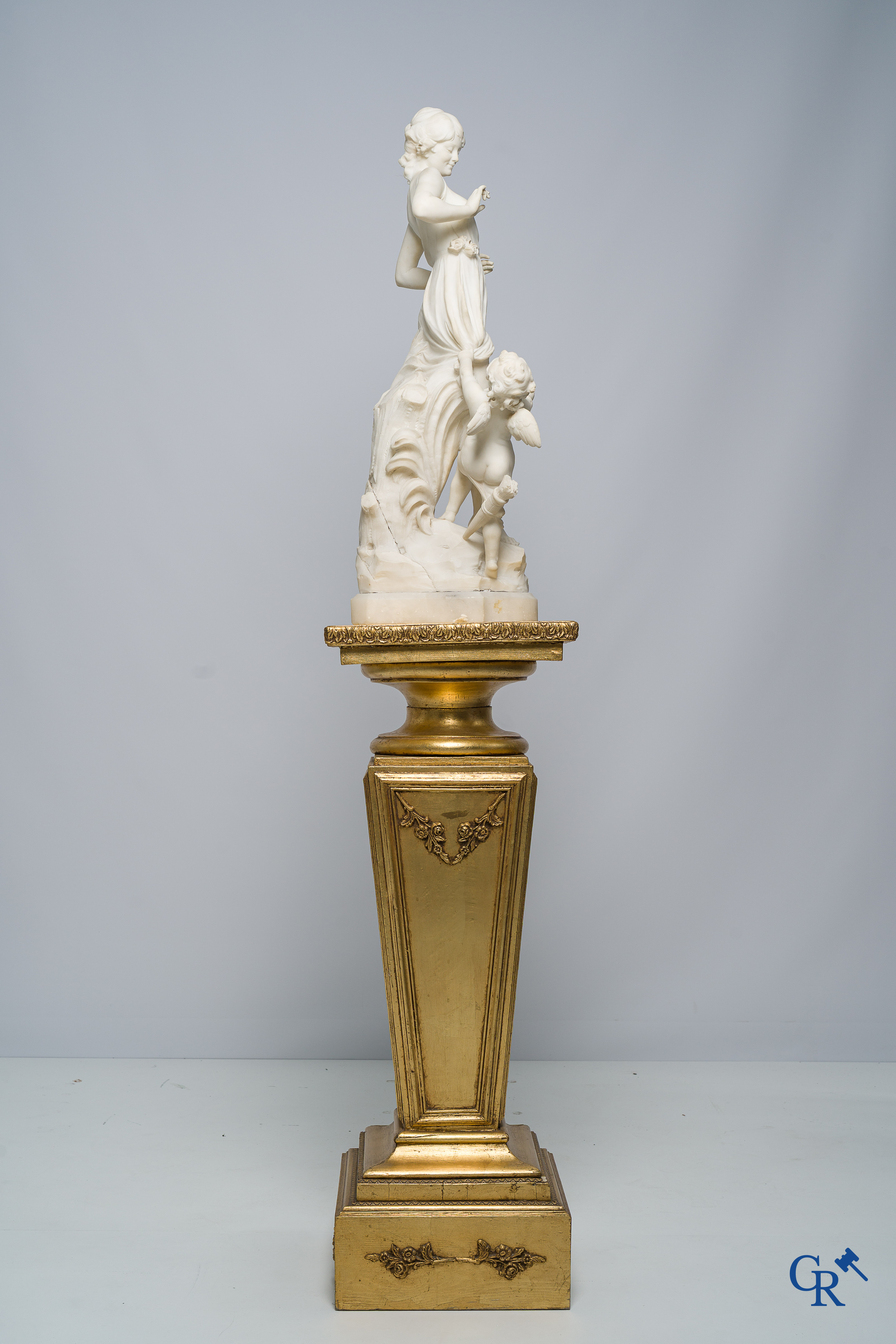 Cipriani. Romantic representation in sculpted marble. Young lady with cupid. LXVI style pedestal. Circa 1900.