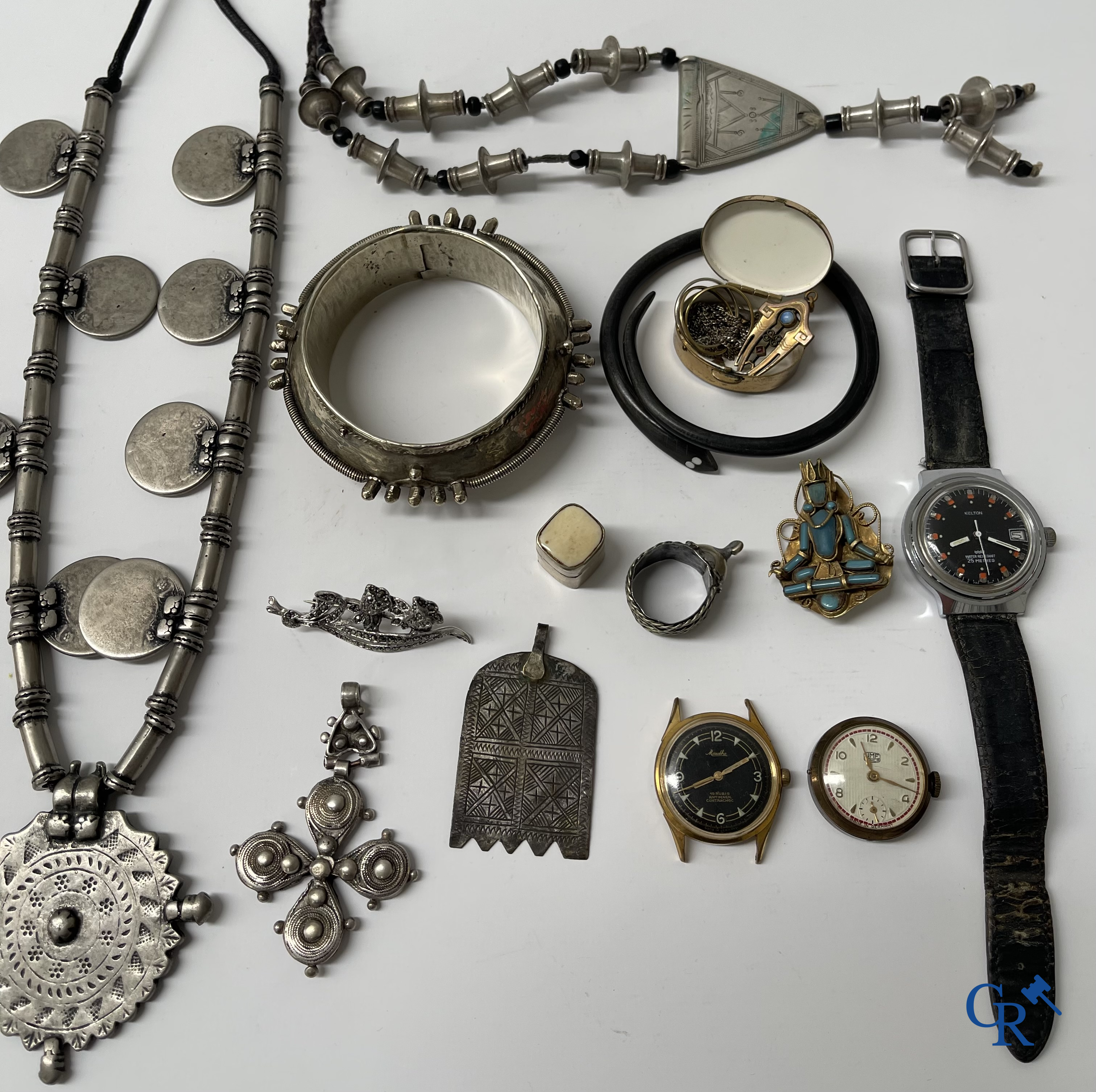 Juwelen. Lot objecten en juwelen in zilver of met zilver montuur. Een lot met uurwerken en juwelen in metaal bijgevoegd.