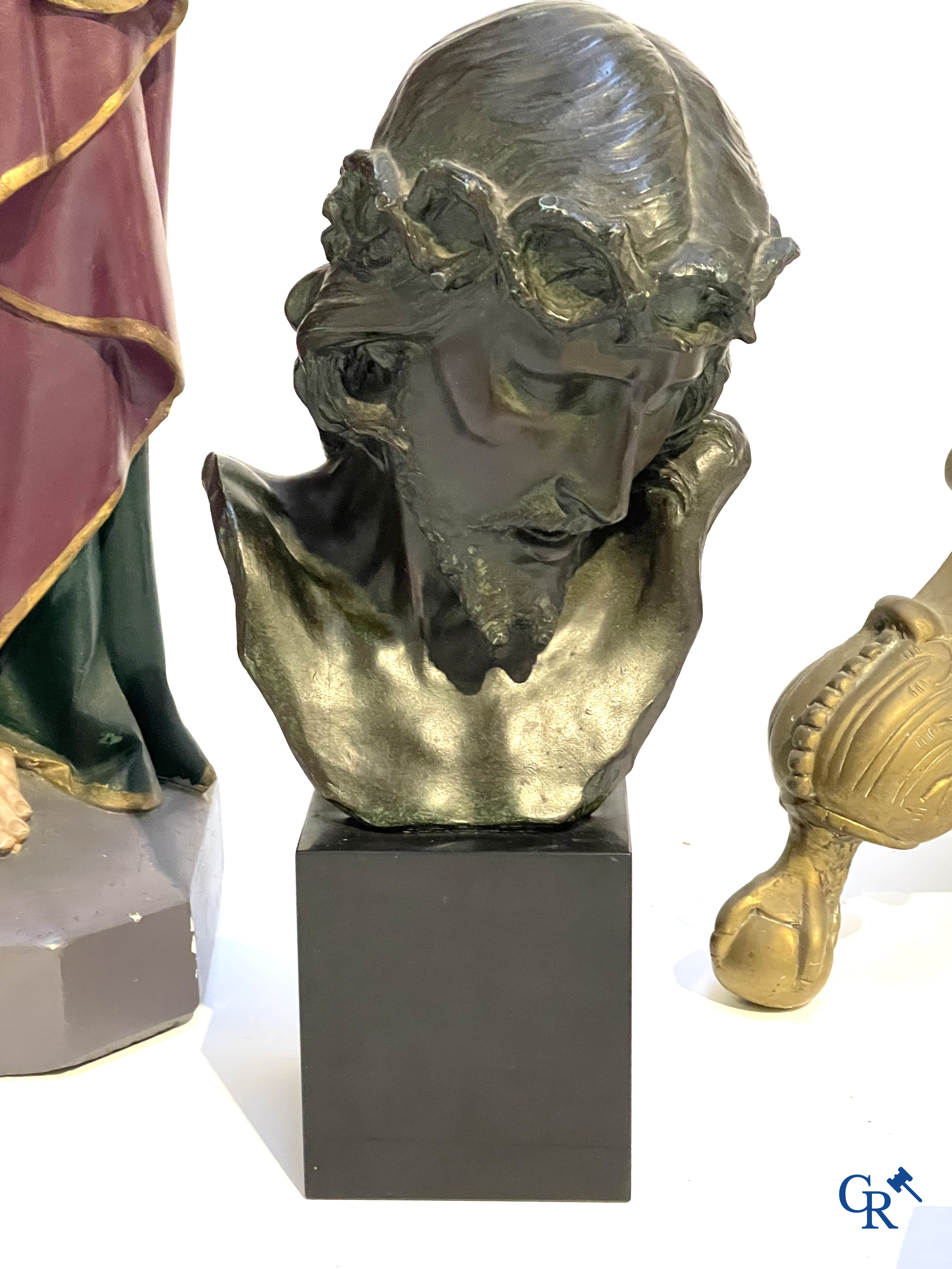 A large bronze candlestick, Saint Joseph with child in plaster, a terracotta bust of Christ and a holy water vessel.