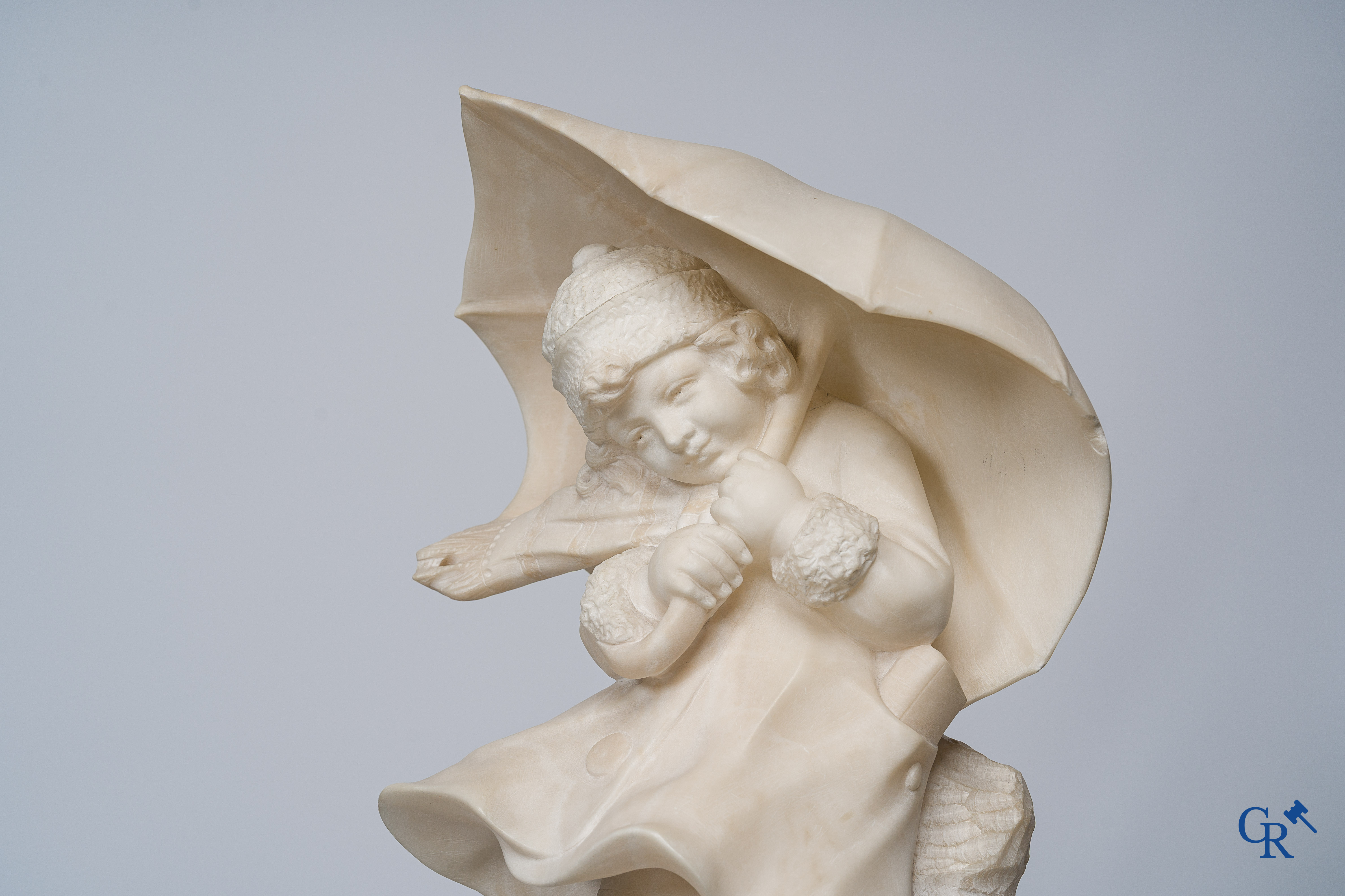 Amusing statue of a girl with umbrella in sculpted marble. No signature noticeable. Around 1920.