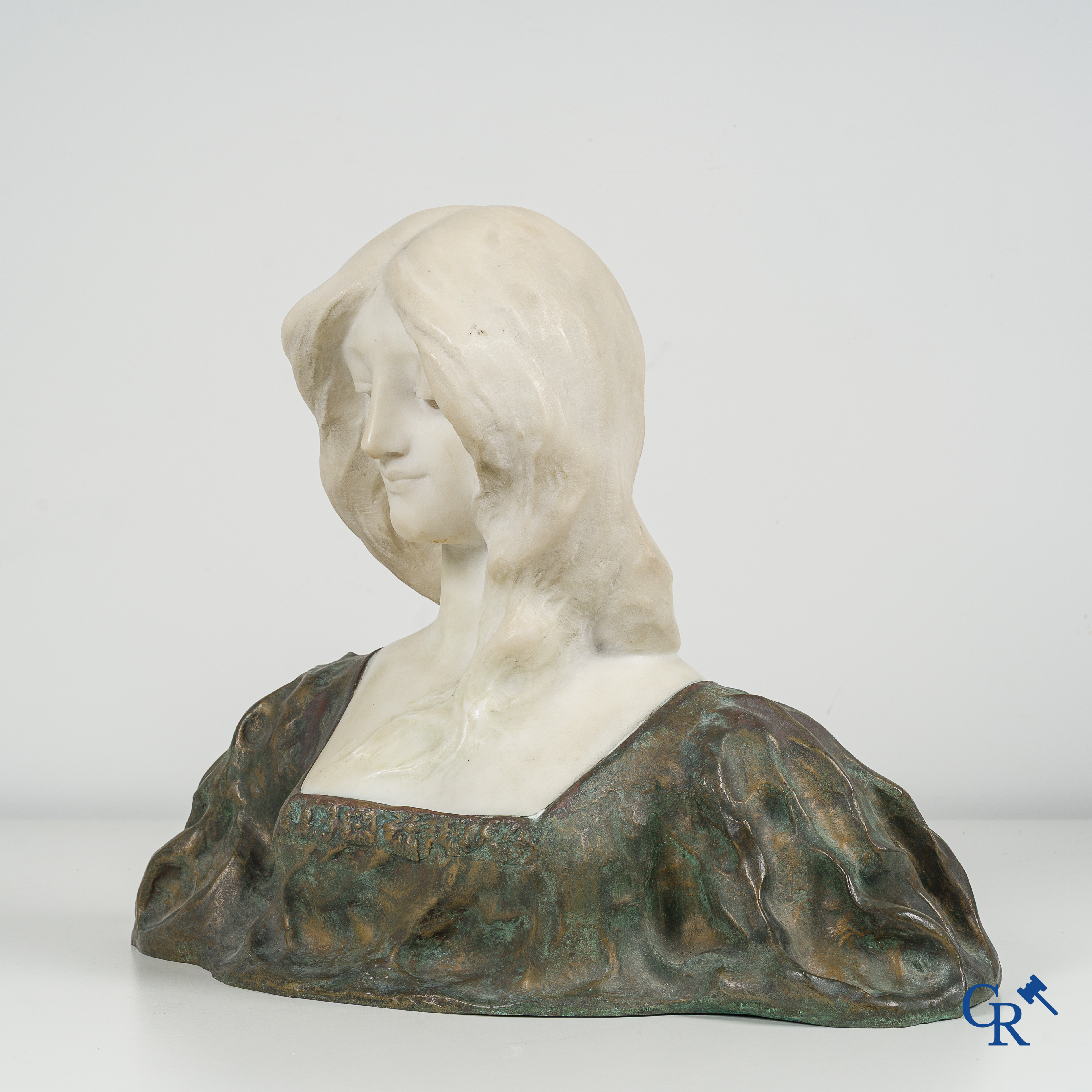 Art Nouveau. Bust of a young lady in Carrara marble and brown-green patinated bronze. Signed, circa 1900.