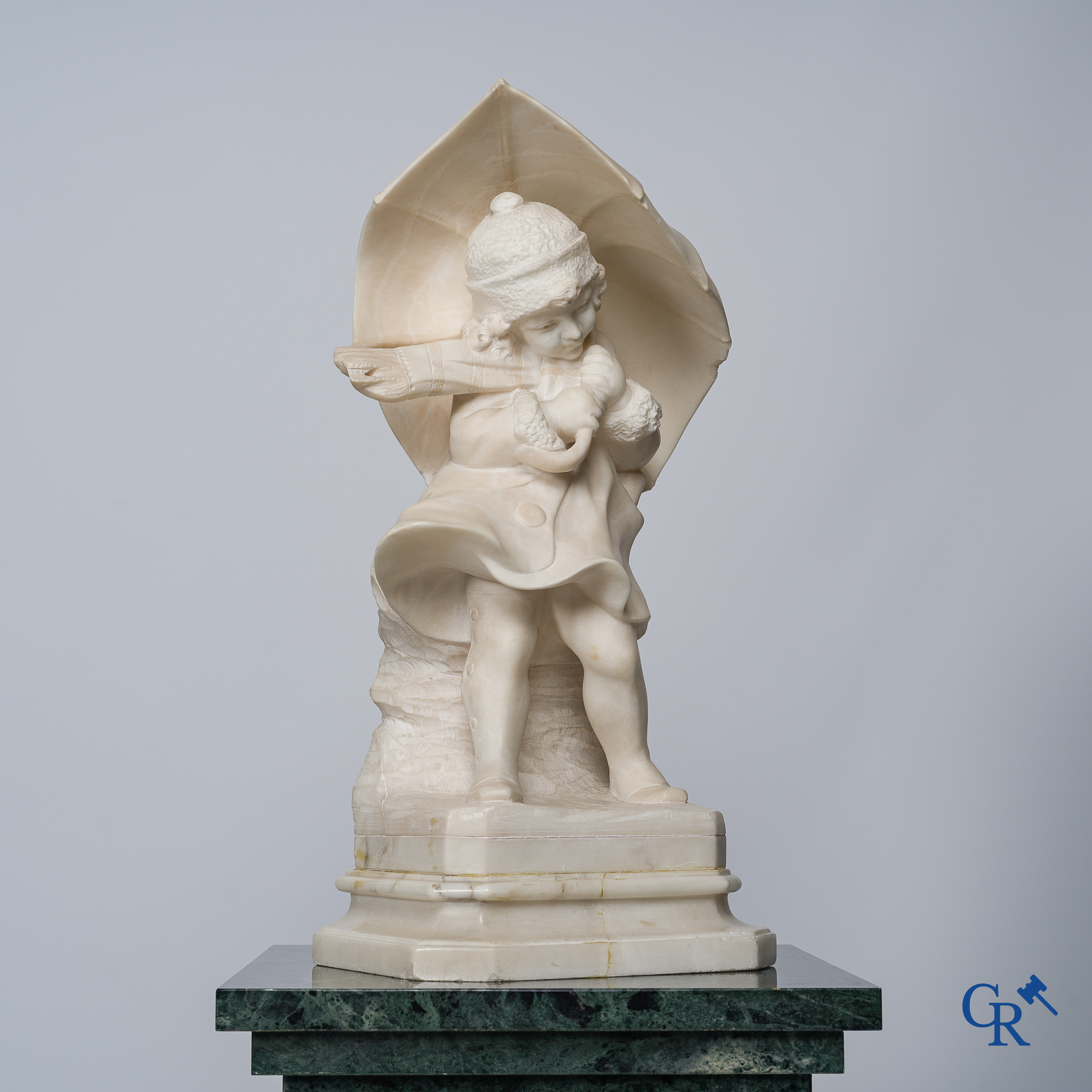 Amusing statue of a girl with umbrella in sculpted marble. No signature noticeable. Around 1920.