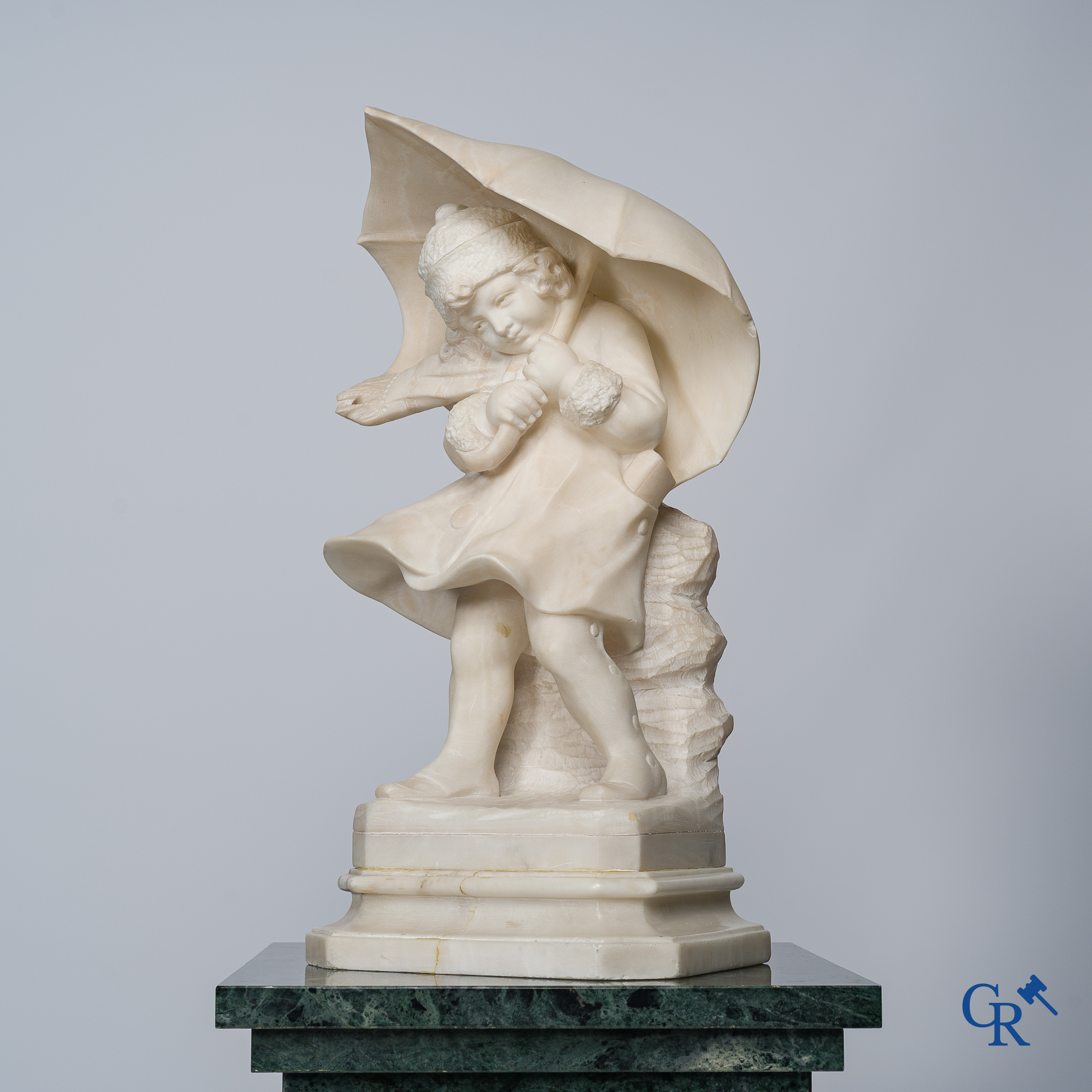 Amusing statue of a girl with umbrella in sculpted marble. No signature noticeable. Around 1920.