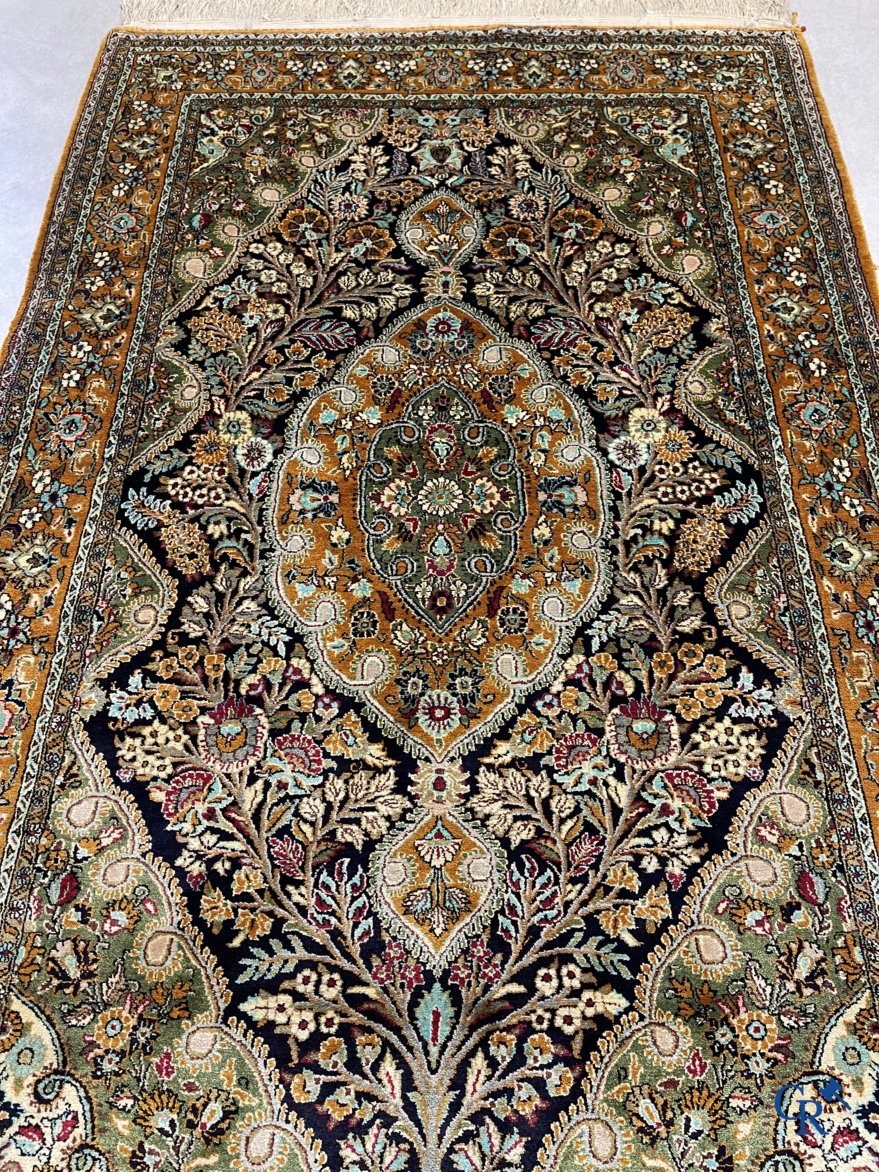 Tapis d'orient. Tapis en soie noué à la main avec un décor floral sur fond orange.
