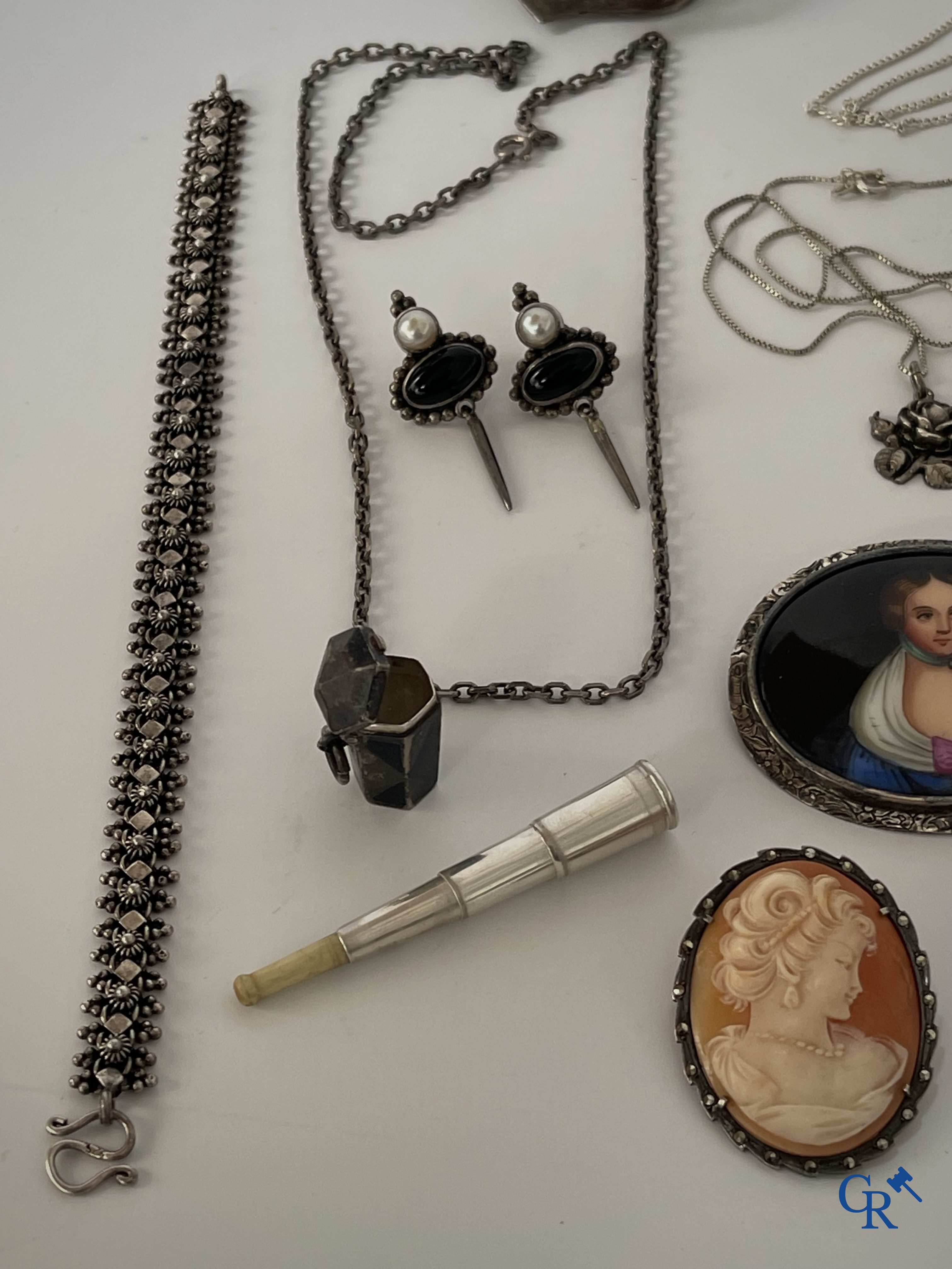 Juwelen. Lot objecten en juwelen in zilver of met zilver montuur. Een lot met uurwerken en juwelen in metaal bijgevoegd.