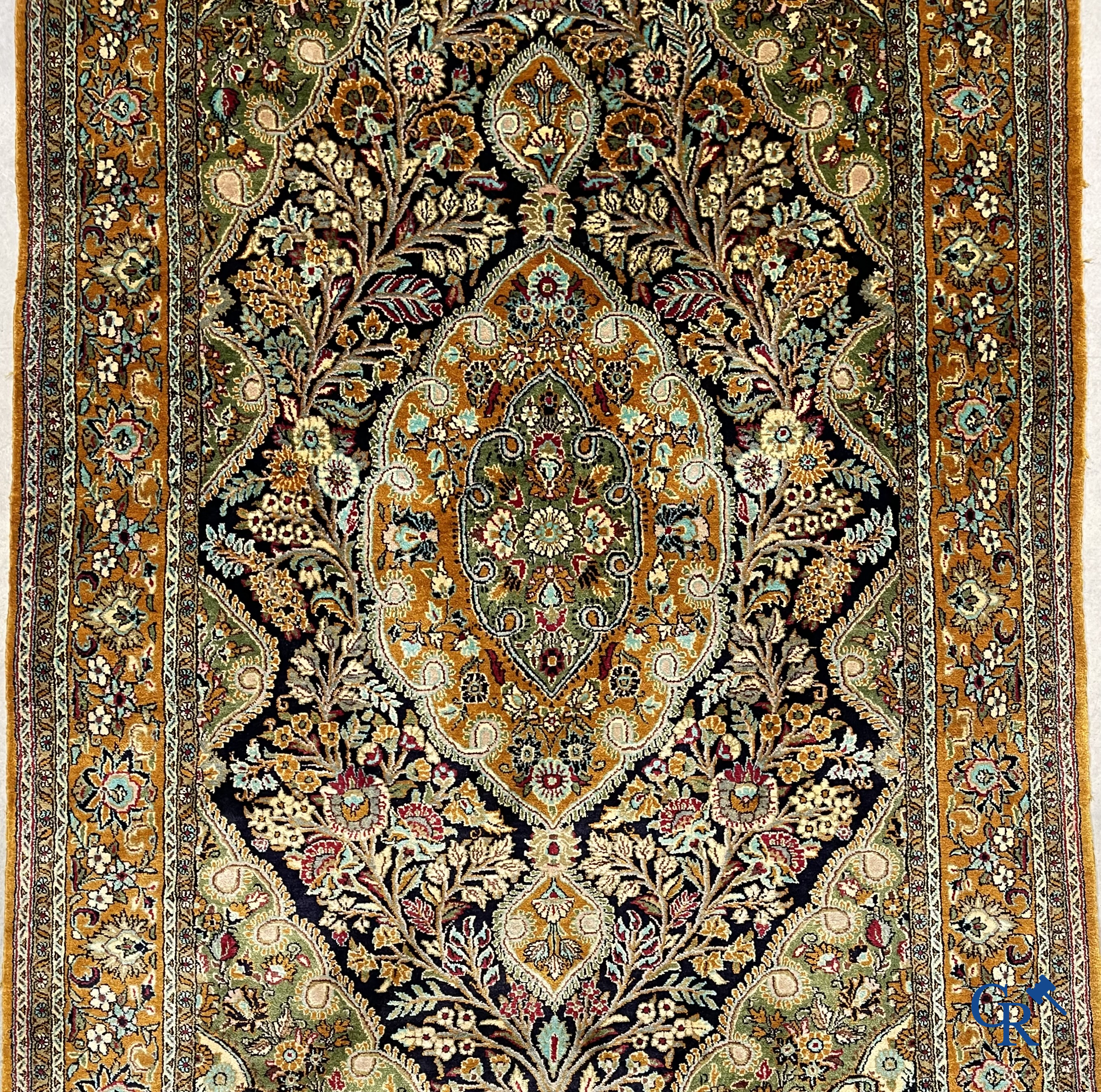 Tapis d'orient. Tapis en soie noué à la main avec un décor floral sur fond orange.