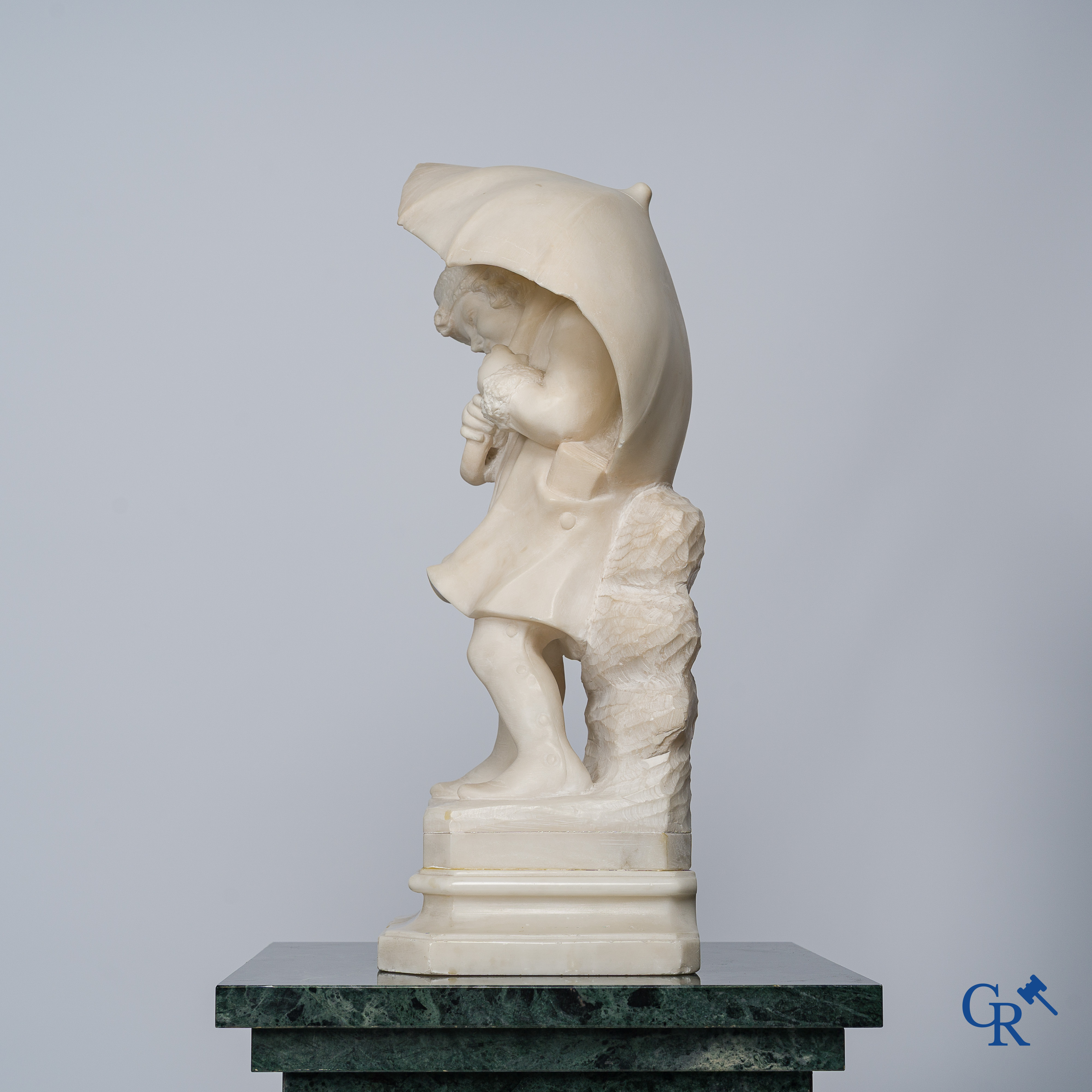 Amusing statue of a girl with umbrella in sculpted marble. No signature noticeable. Around 1920.