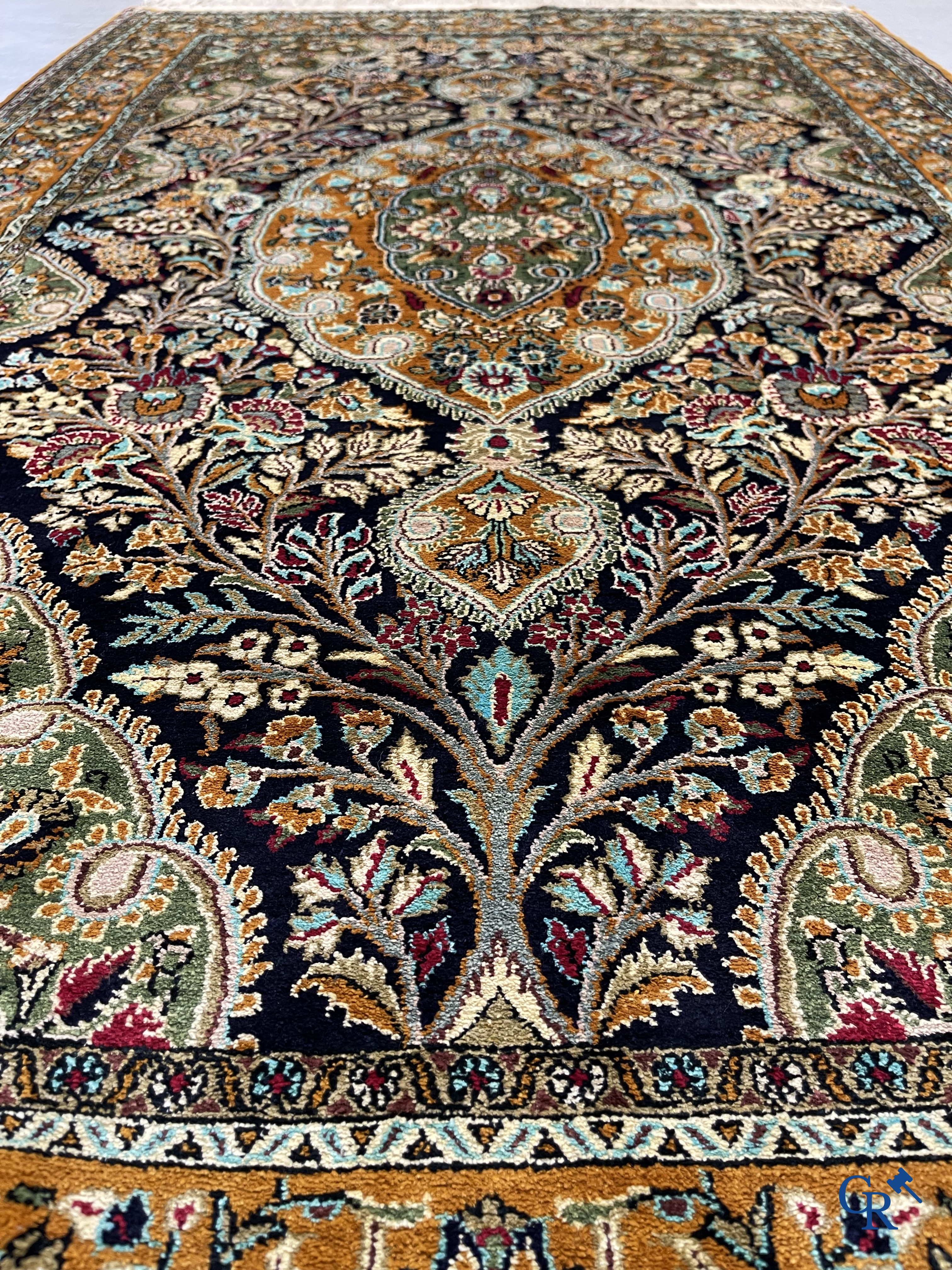 Tapis d'orient. Tapis en soie noué à la main avec un décor floral sur fond orange.
