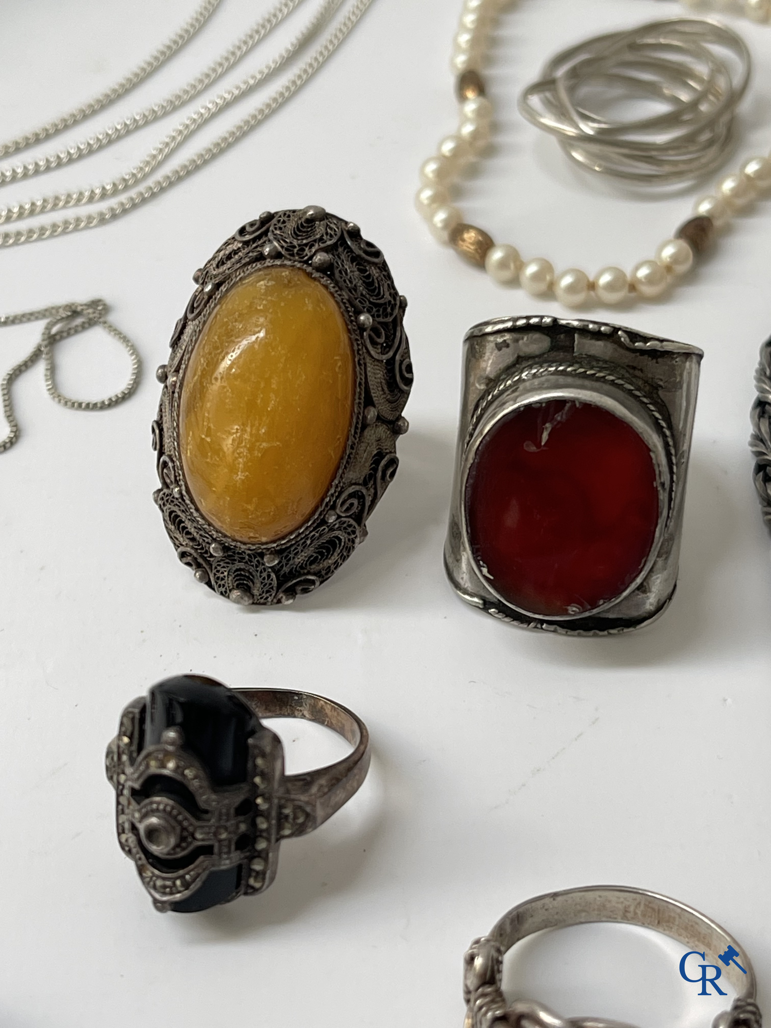 Juwelen. Lot objecten en juwelen in zilver of met zilver montuur. Een lot met uurwerken en juwelen in metaal bijgevoegd.