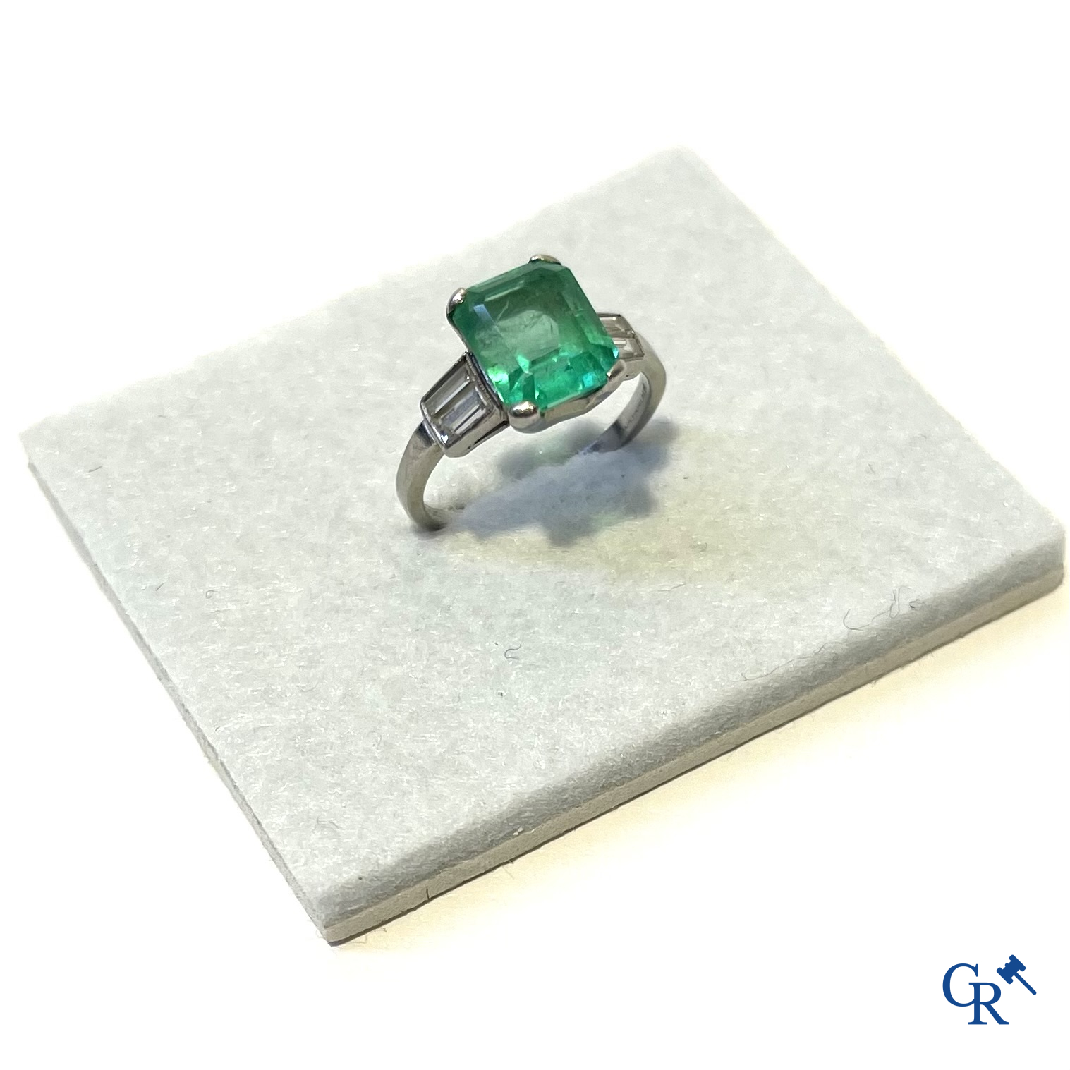 Jewellery. A platinum ring with emerald and diamonds and a pendant in white gold 750°/00 with emerald and 14 diamonds.