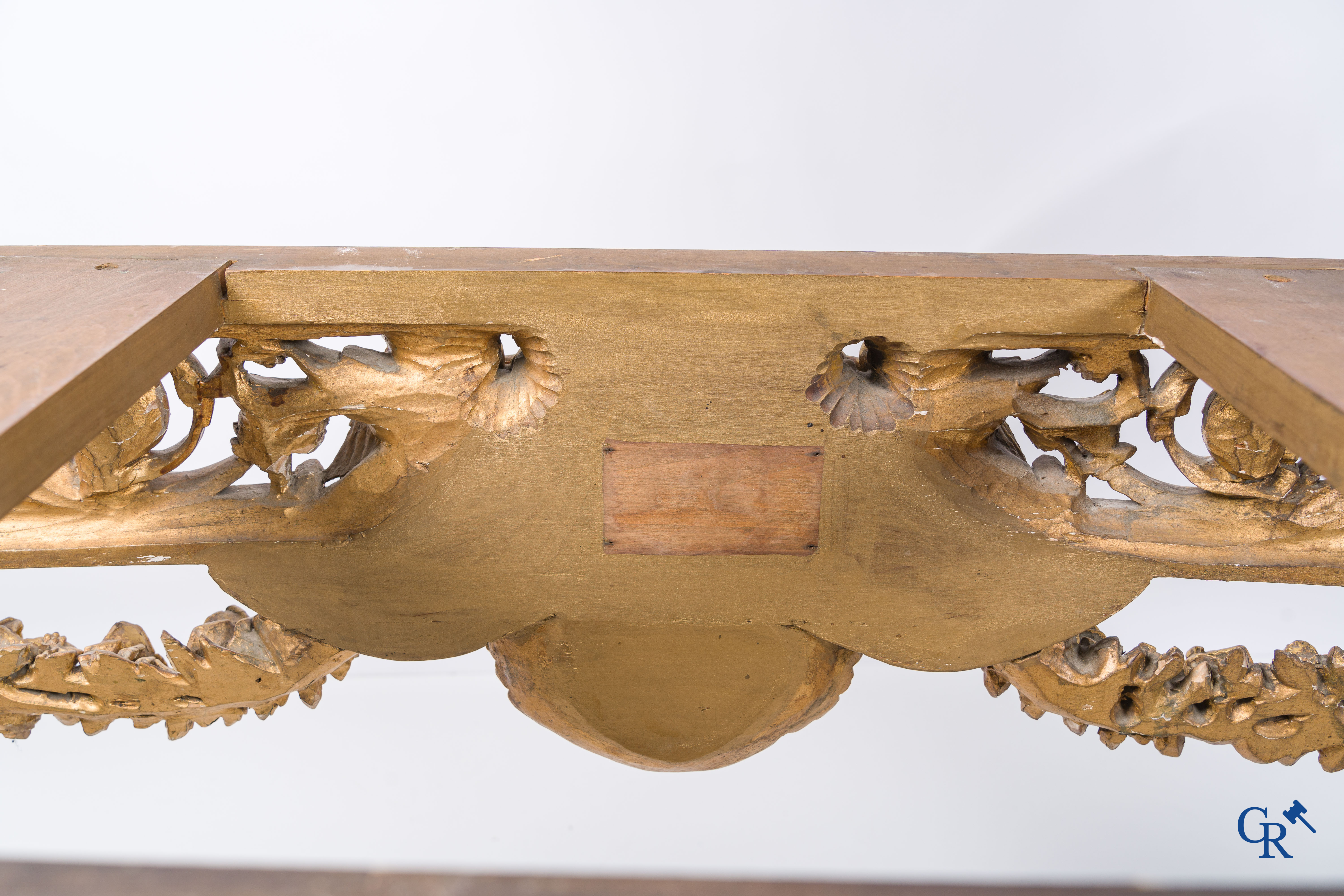 A richly carved and gilded console table in LVXI style with a grisaille painting on marble.