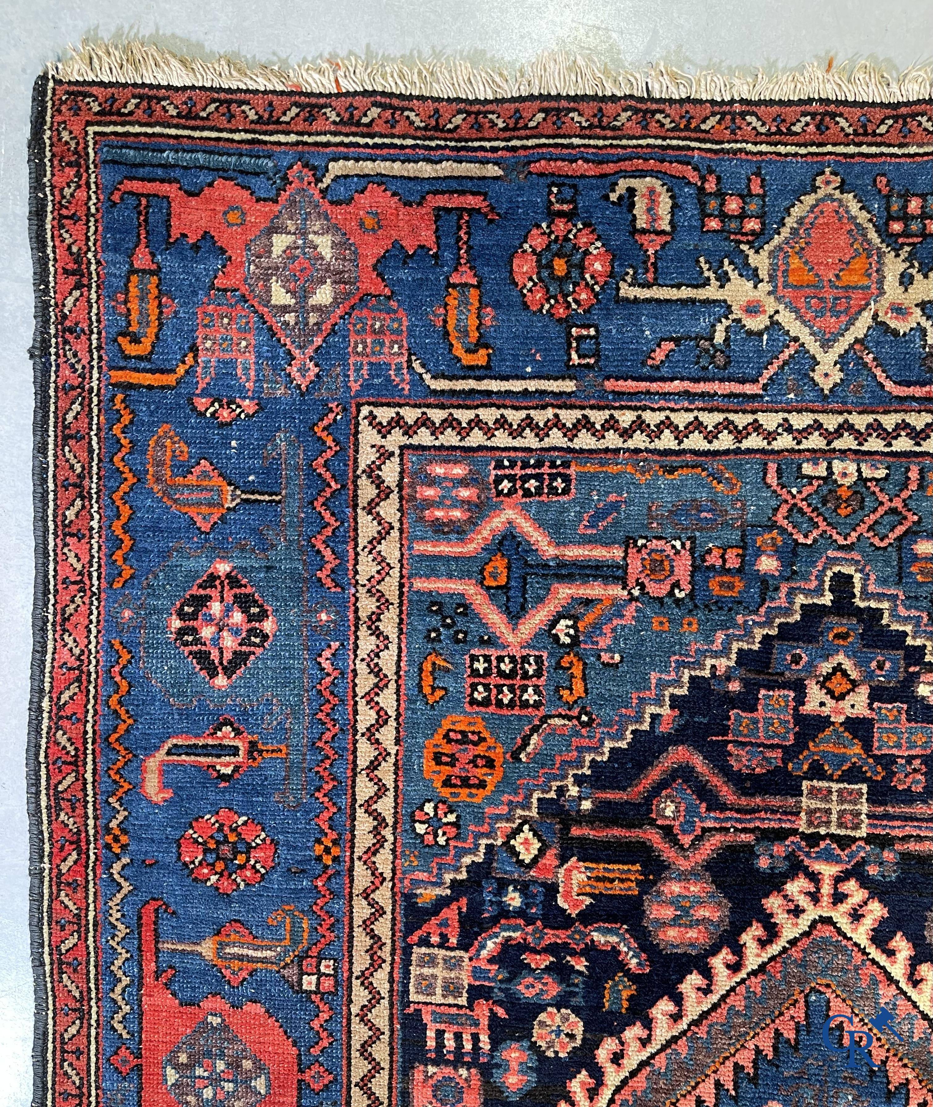 Antique Oriental carpets, an antique hand-knotted carpet with motifs on a blue background.