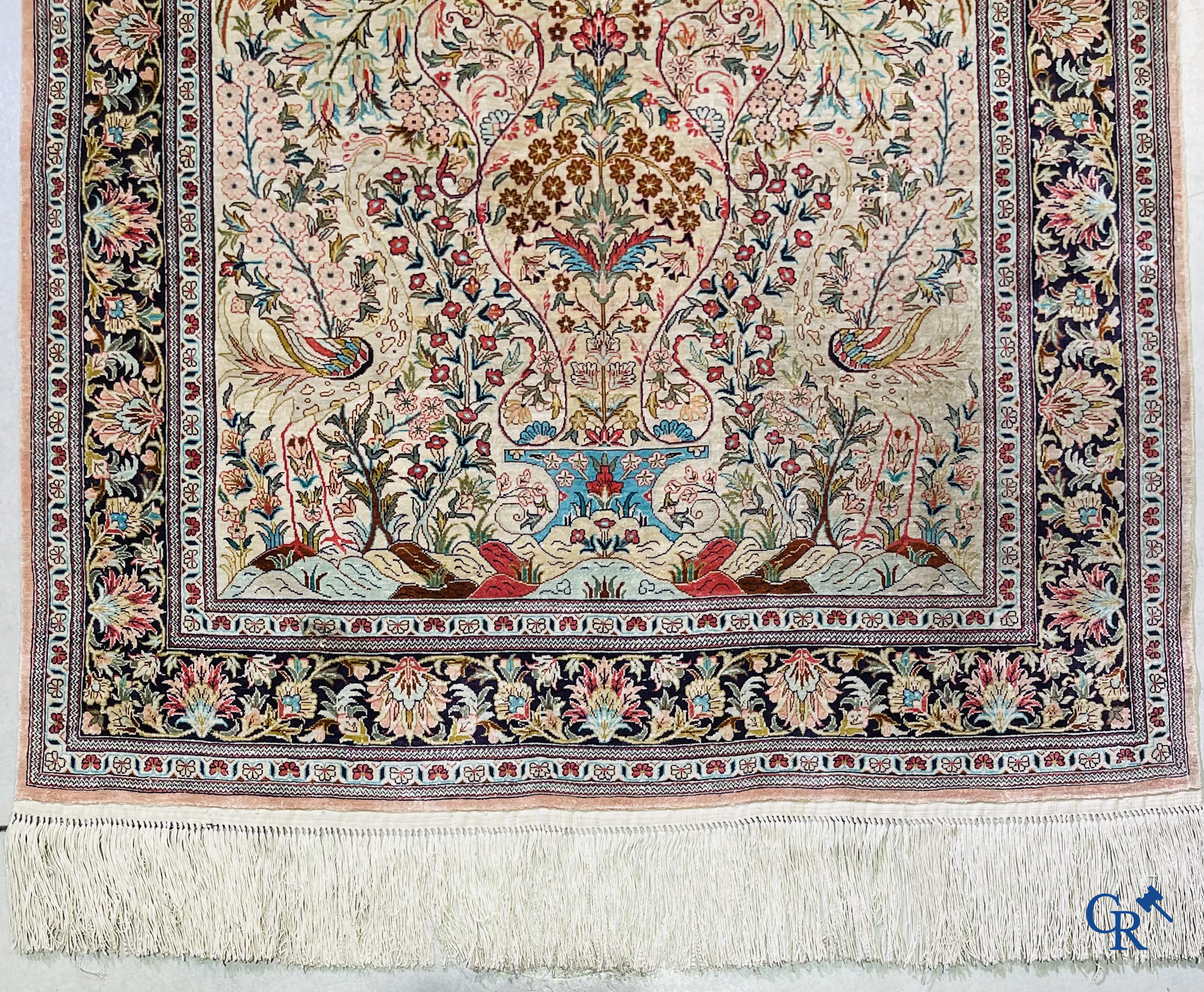 Tapis d'Orient: Un tapis persan en soie finement noué à la main avec un vase à fleurs et des oiseaux dans un décor floral.