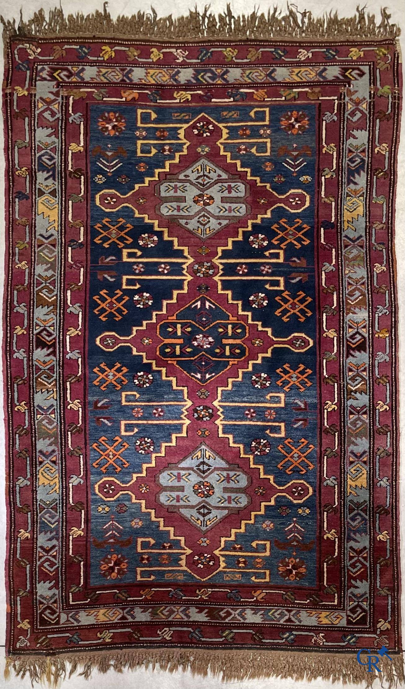 Oriental carpets, an antique hand-knotted Oriental carpet with motifs on a blue background.