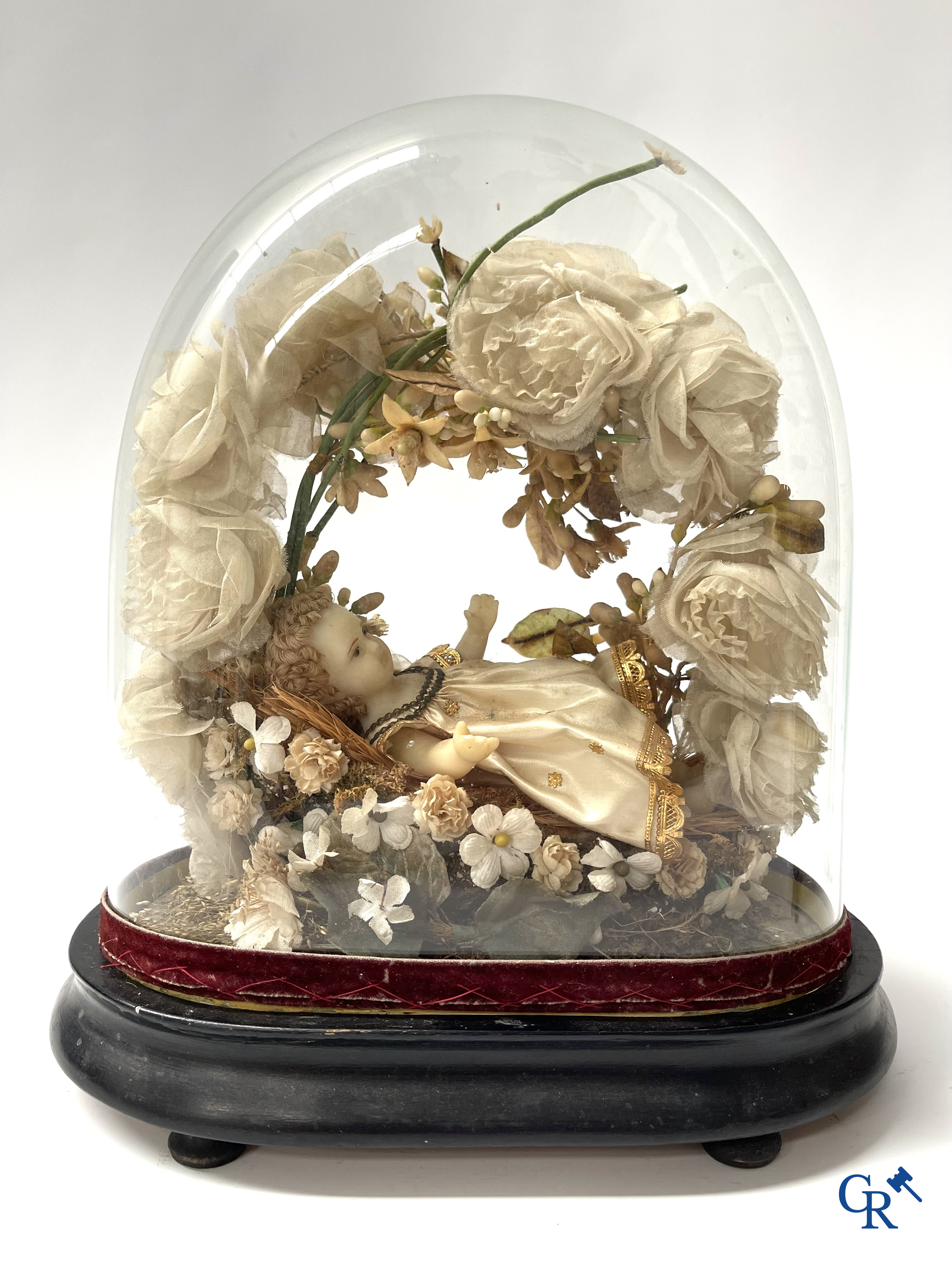 Un globe en verre avec un enfant en cire et une vitrine en laiton avec bouquet de mariée. Vers 1900.