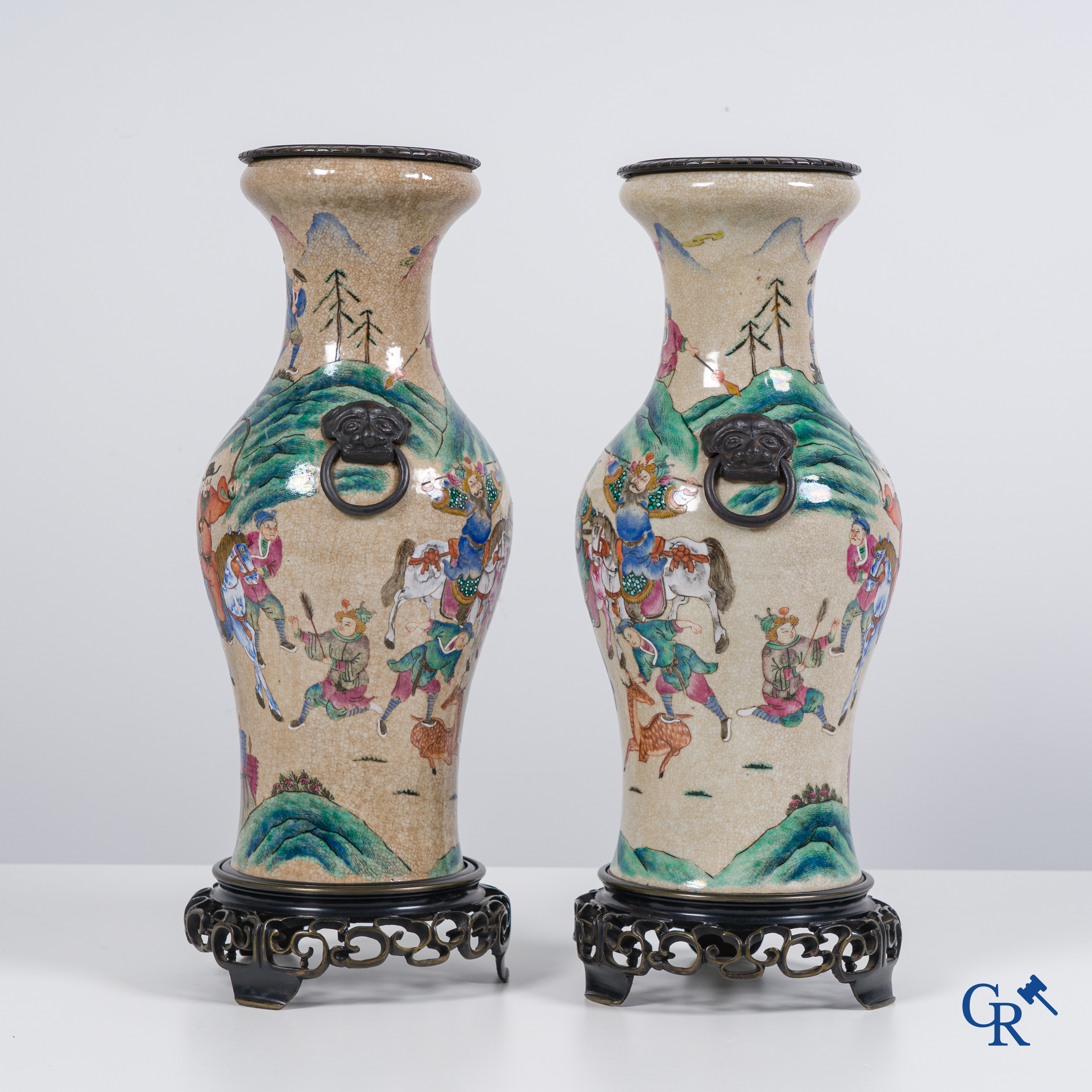 Asian Art: Chinese porcelain. A pair of finely decorated famille rose vases in a bronze frame. 19th century.