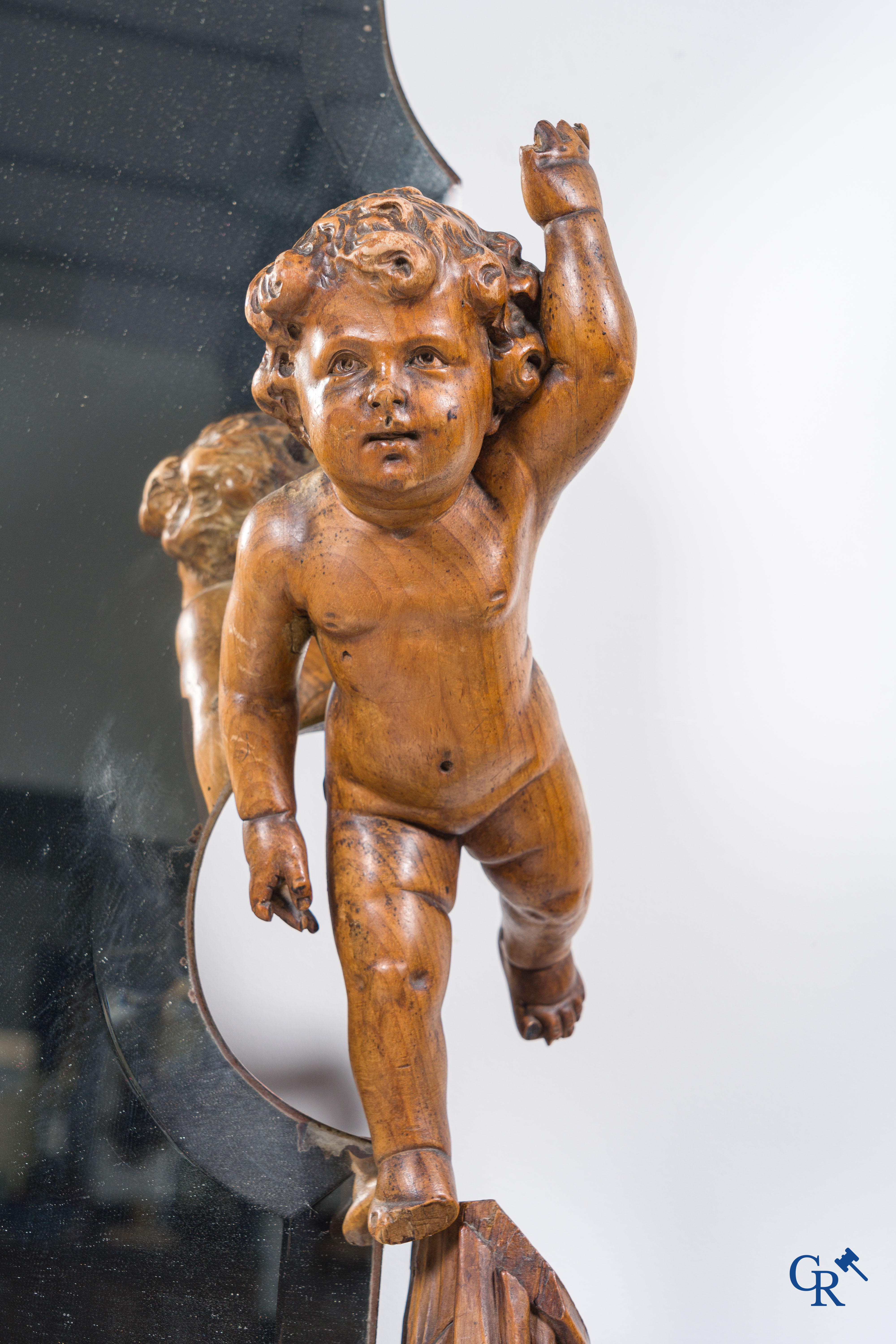 Een grote spiegel omringd met 6 hout gesculpteerde putti. Circa 1900.