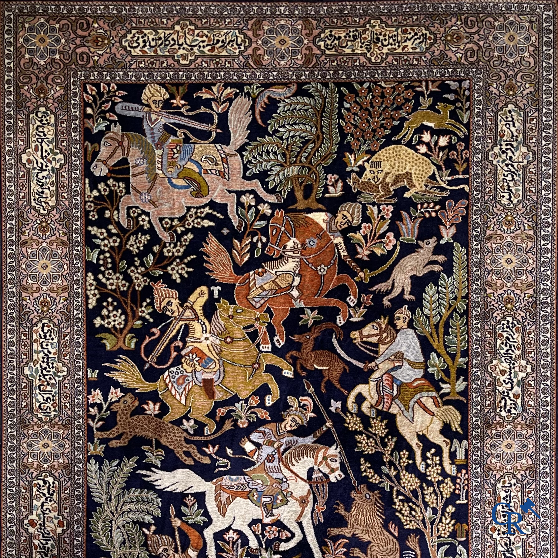 Oriental rugs. Iran. A finely hand-knotted Persian rug in wool and silk with hunters on horseback and inscriptions.