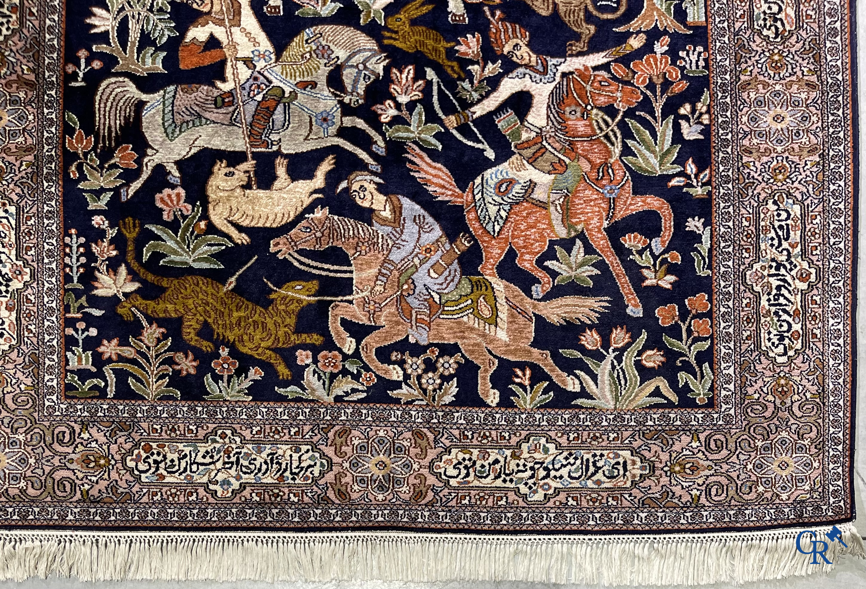 Oriental rugs. Iran. A finely hand-knotted Persian rug in wool and silk with hunters on horseback and inscriptions.