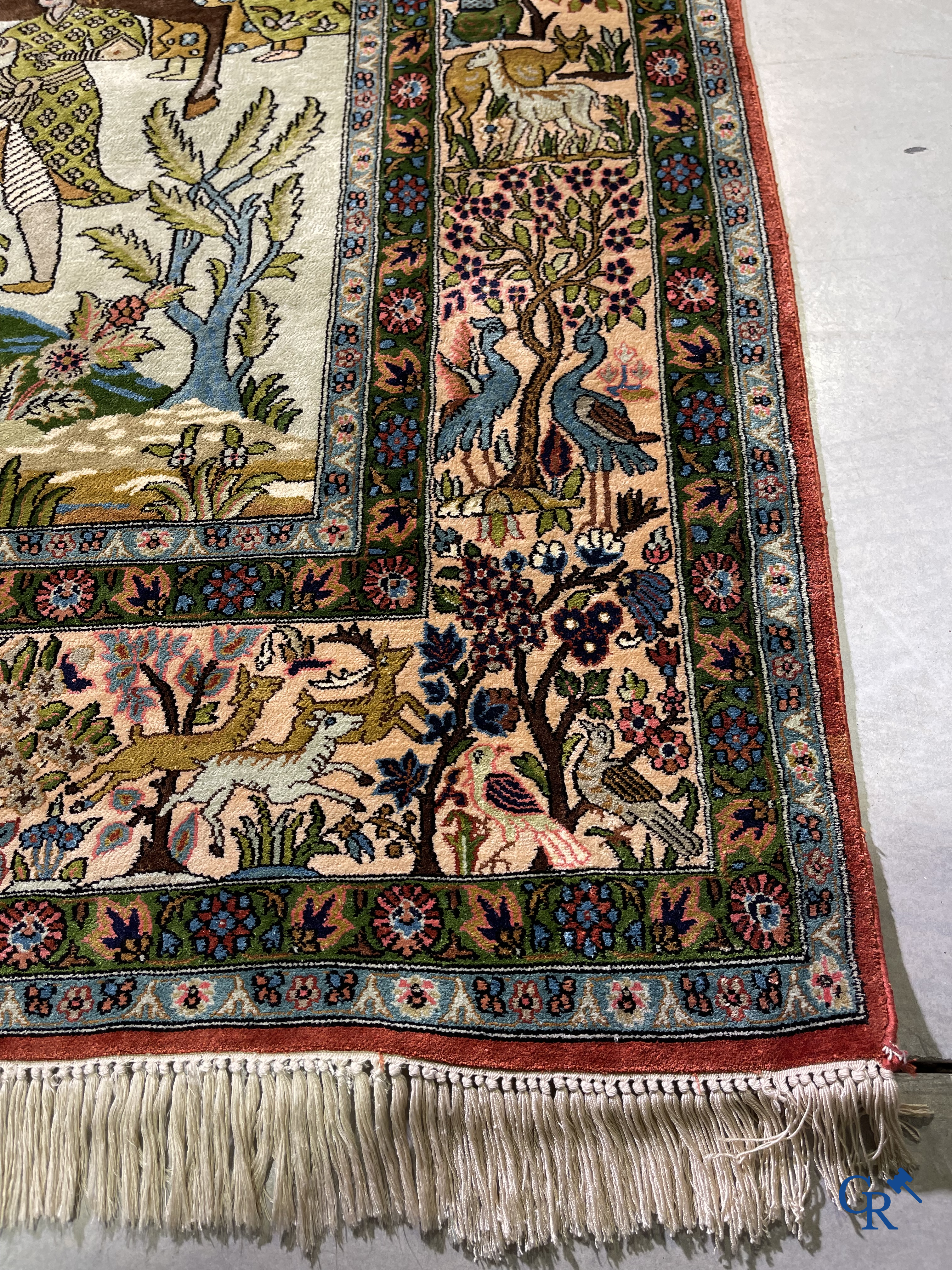 Tapis d'Orient. Iran. Un tapis persan en soie finement noué à la main avec des personnages et un cheval dans un paysage.