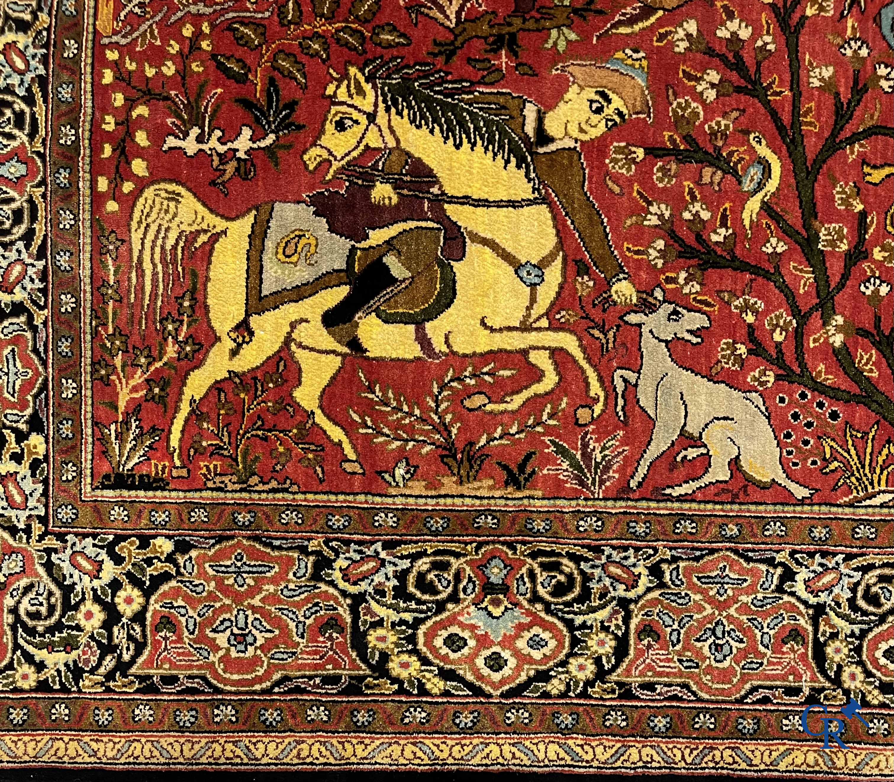 Oriental carpets, a Persian carpet in silk with a scene of hunters on horseback.