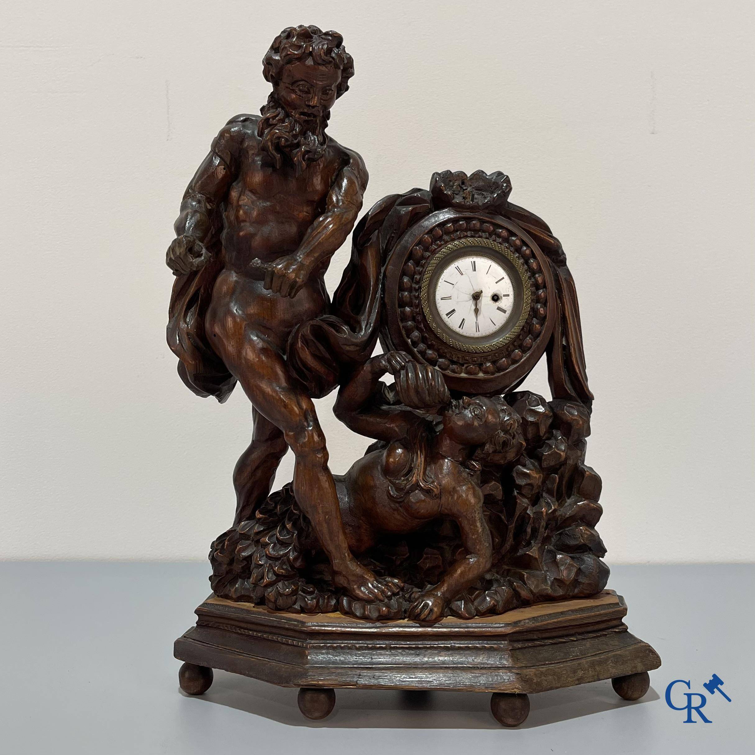 An 18th century wood carved table clock with finely chiseled English watchwork.