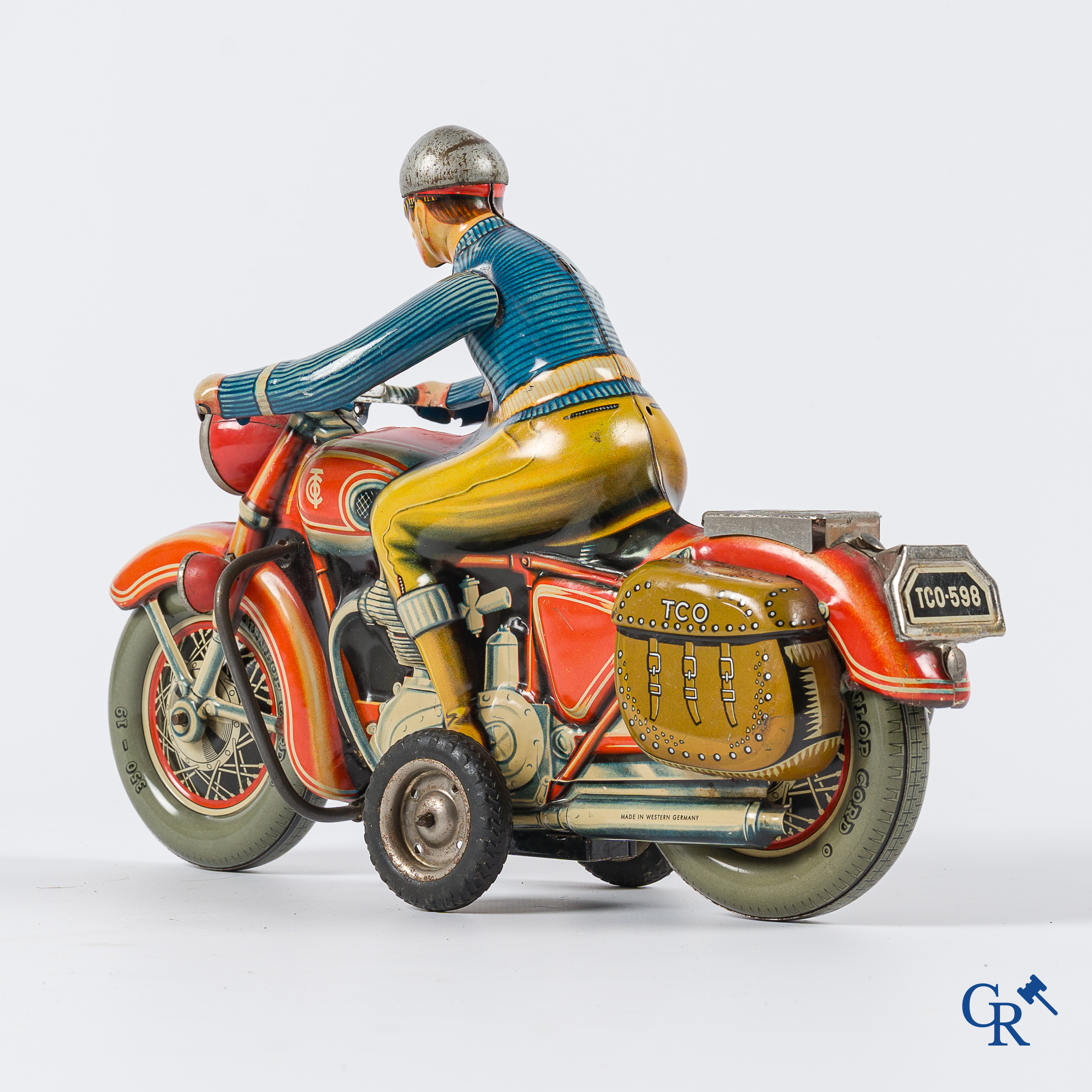Oud speelgoed. Tipco, Western Germany. Motorfiets in beschilderd blik. Jaren '50.