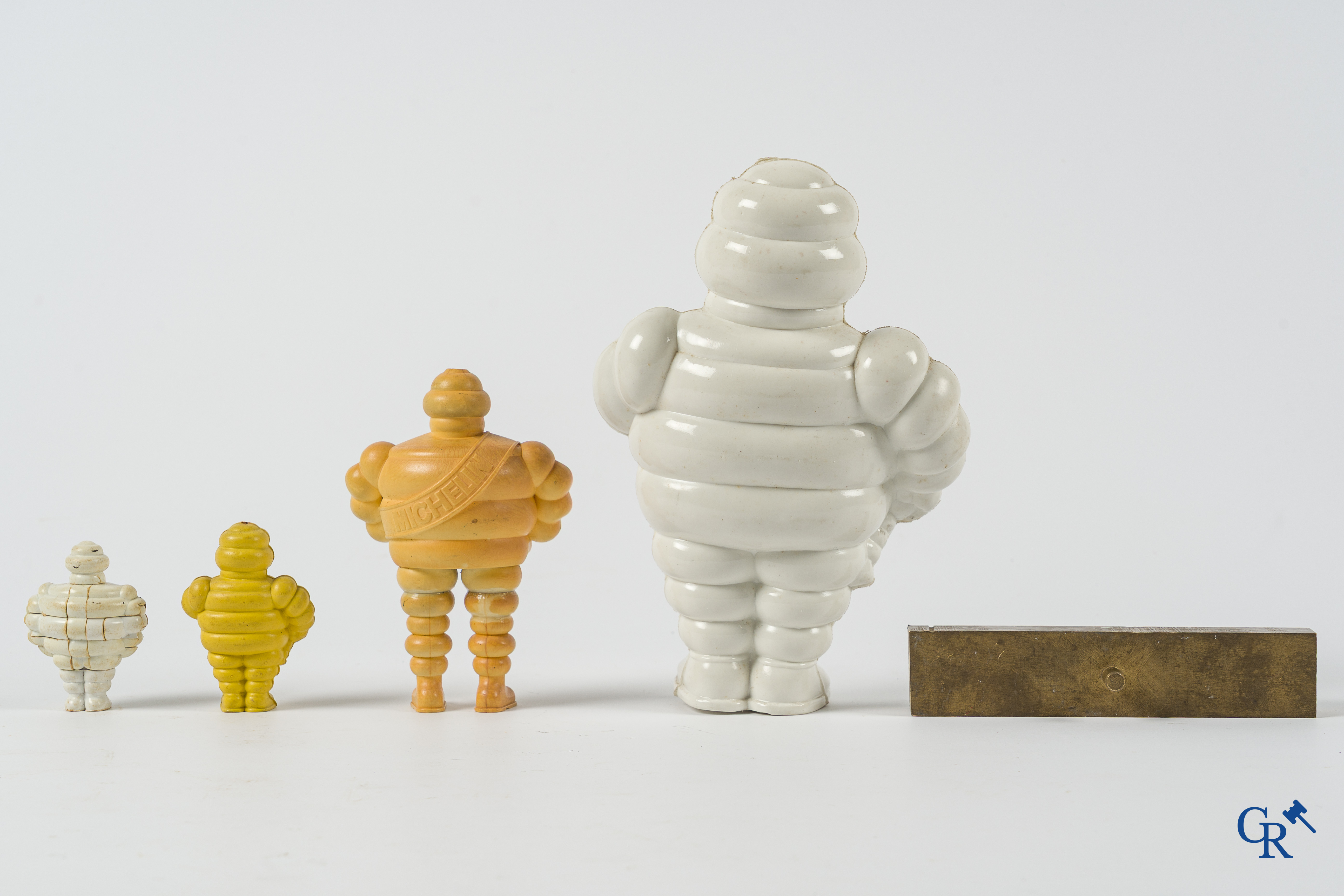 Michelin. Lot de figurines Bibendum, porte-clés Michelin et un orignal timbre d'impression en bronze.
