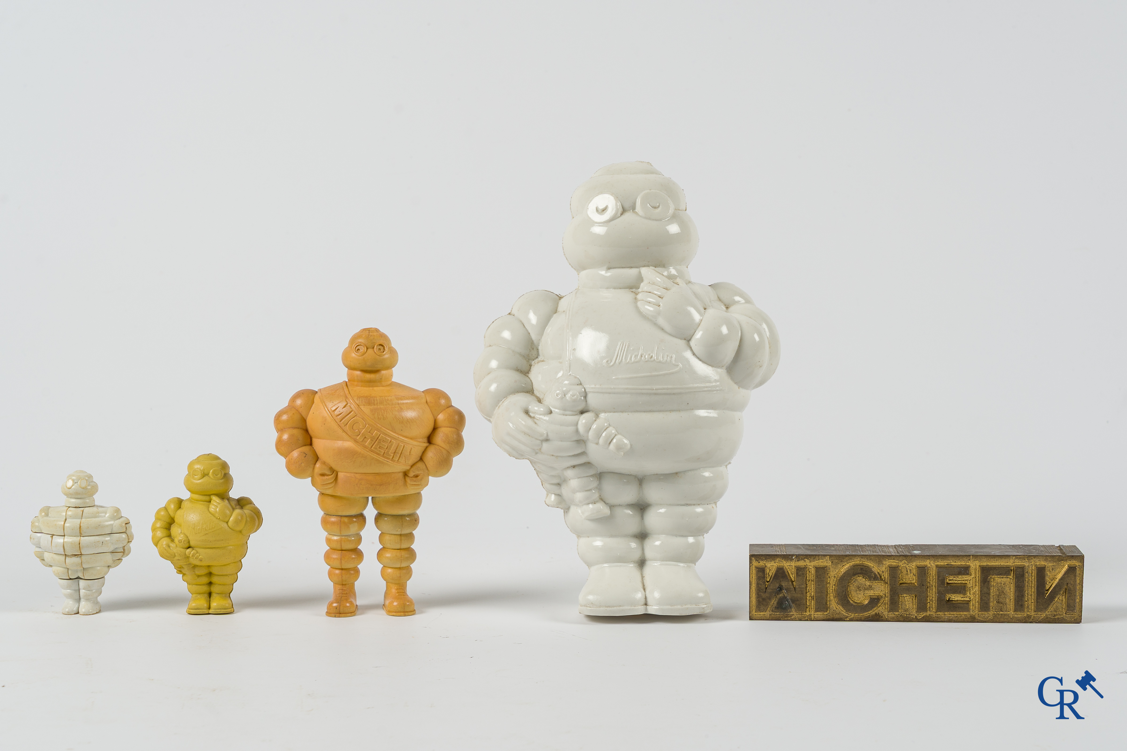 Michelin. Lot de figurines Bibendum, porte-clés Michelin et un orignal timbre d'impression en bronze.