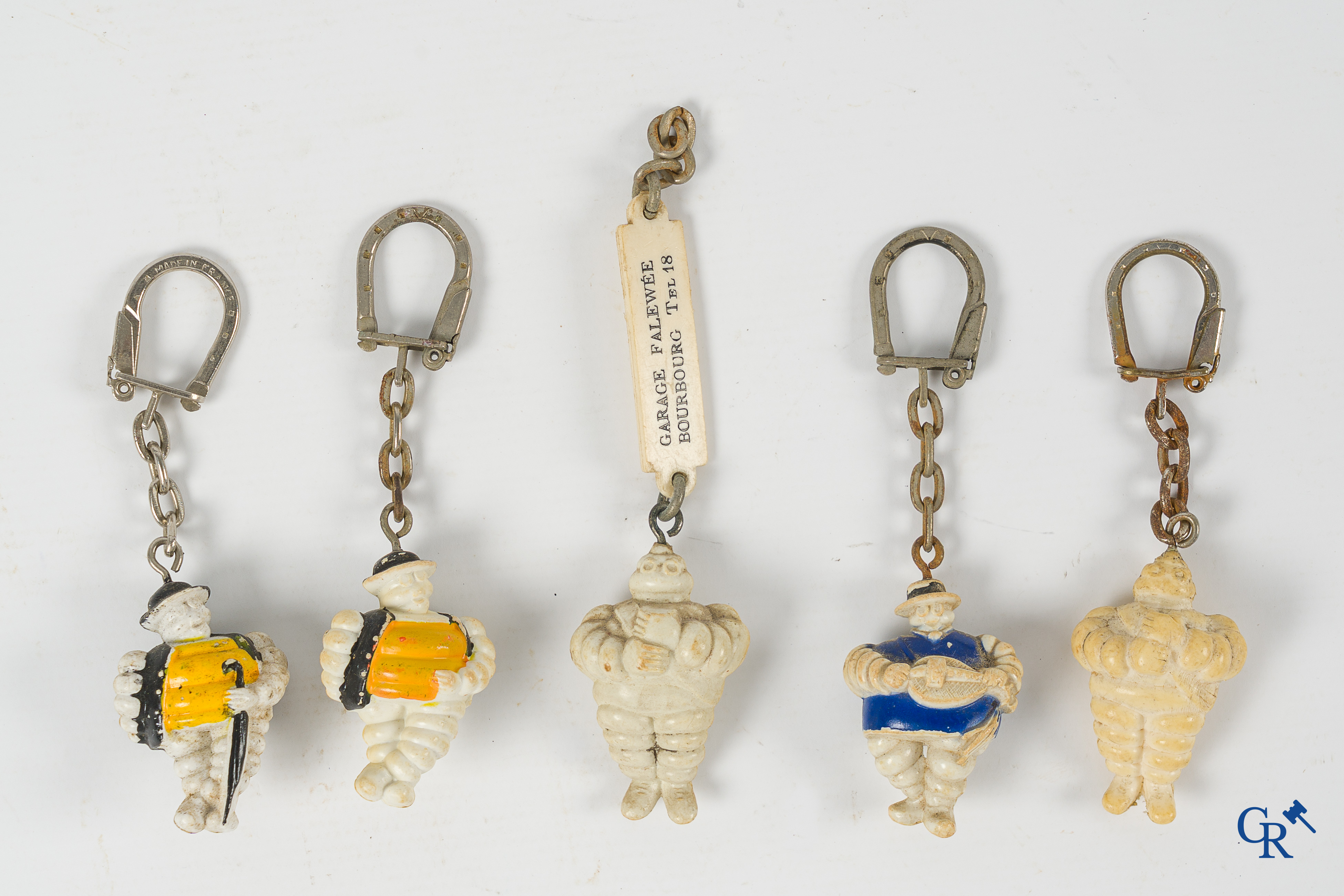 Michelin. Lot de figurines Bibendum, porte-clés Michelin et un orignal timbre d'impression en bronze.